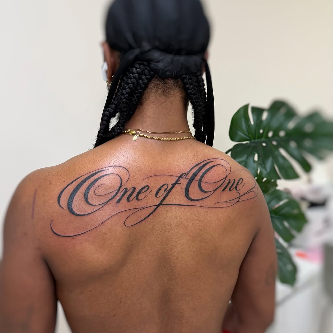 Script lettering lettering tattoo on the back by David