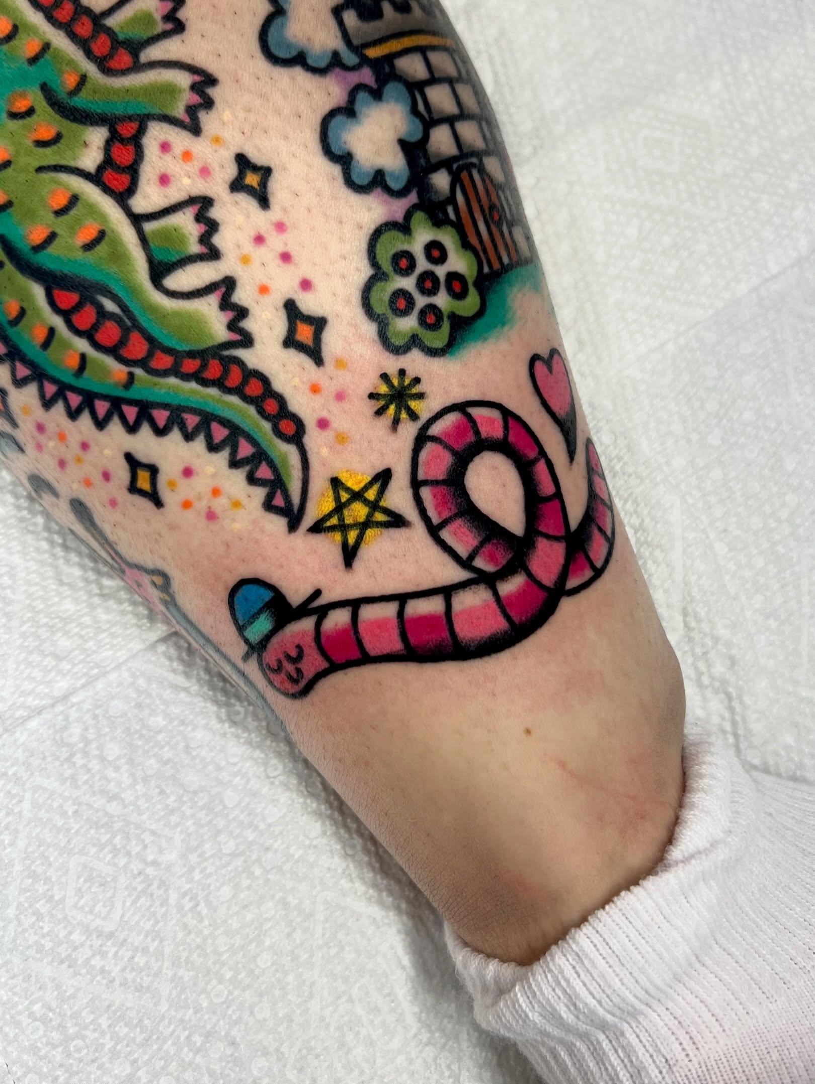 Snake and candy cane Chicano tattoo on the forearm by Sierra Mack