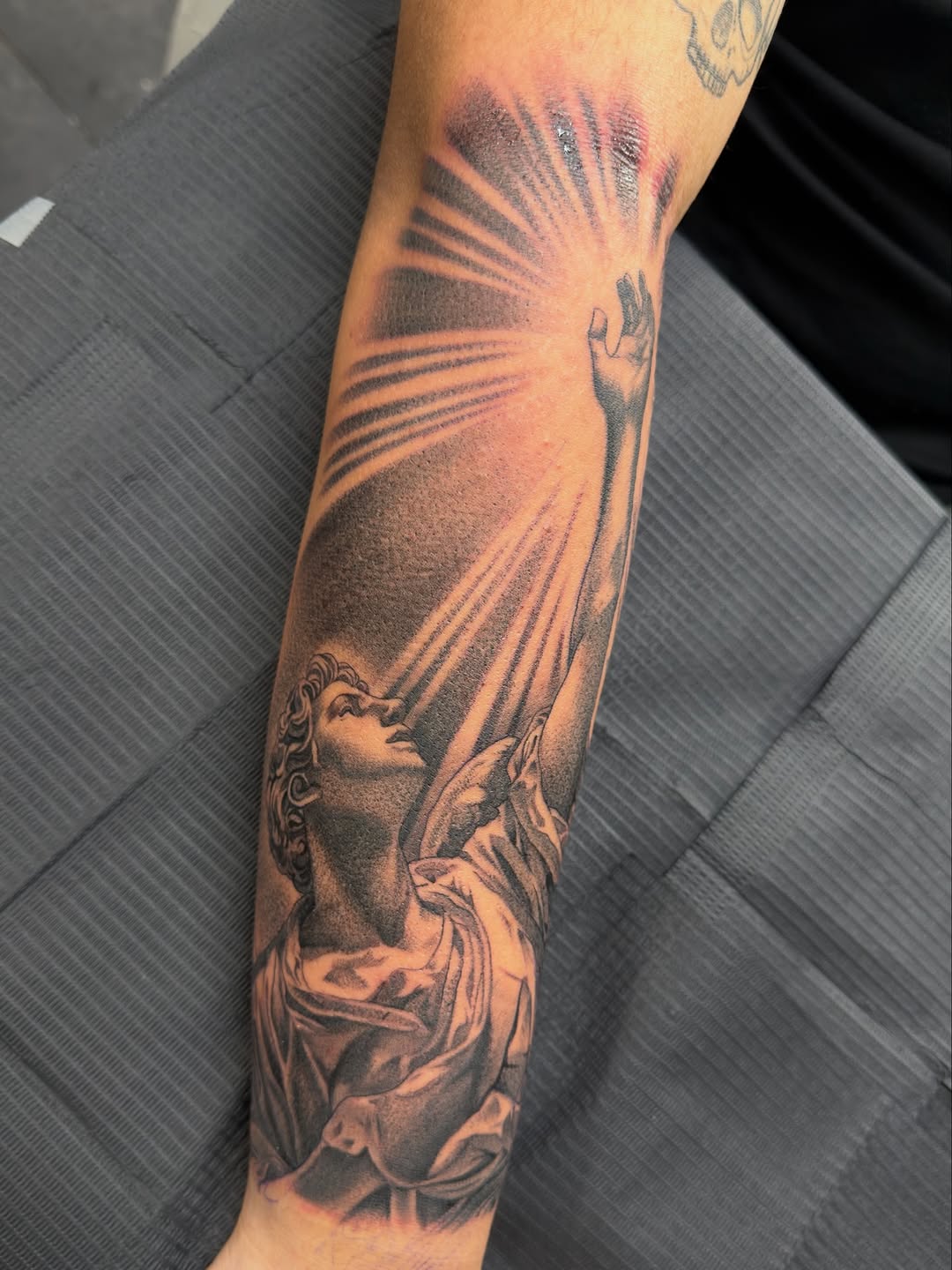 Angel reaching for light realism tattoo on the forearm by Eduardo Chaparro
