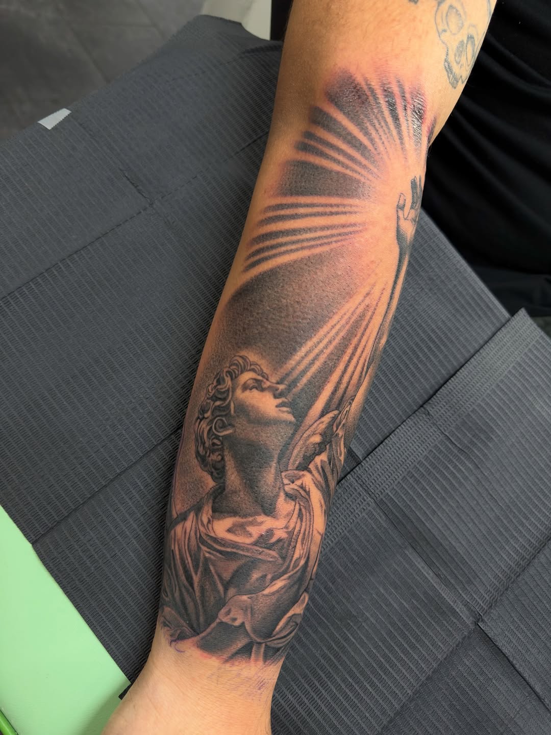 Angel reaching for light realism tattoo on the forearm by Eduardo Chaparro