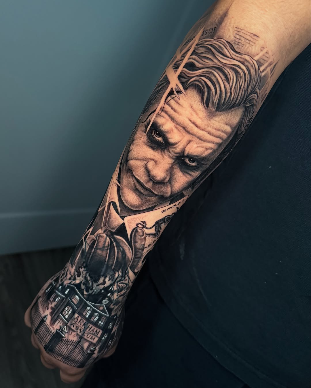 Joker portrait and Arkham Asylum realism tattoo on the forearm by Las Vegas Tattoo Artist