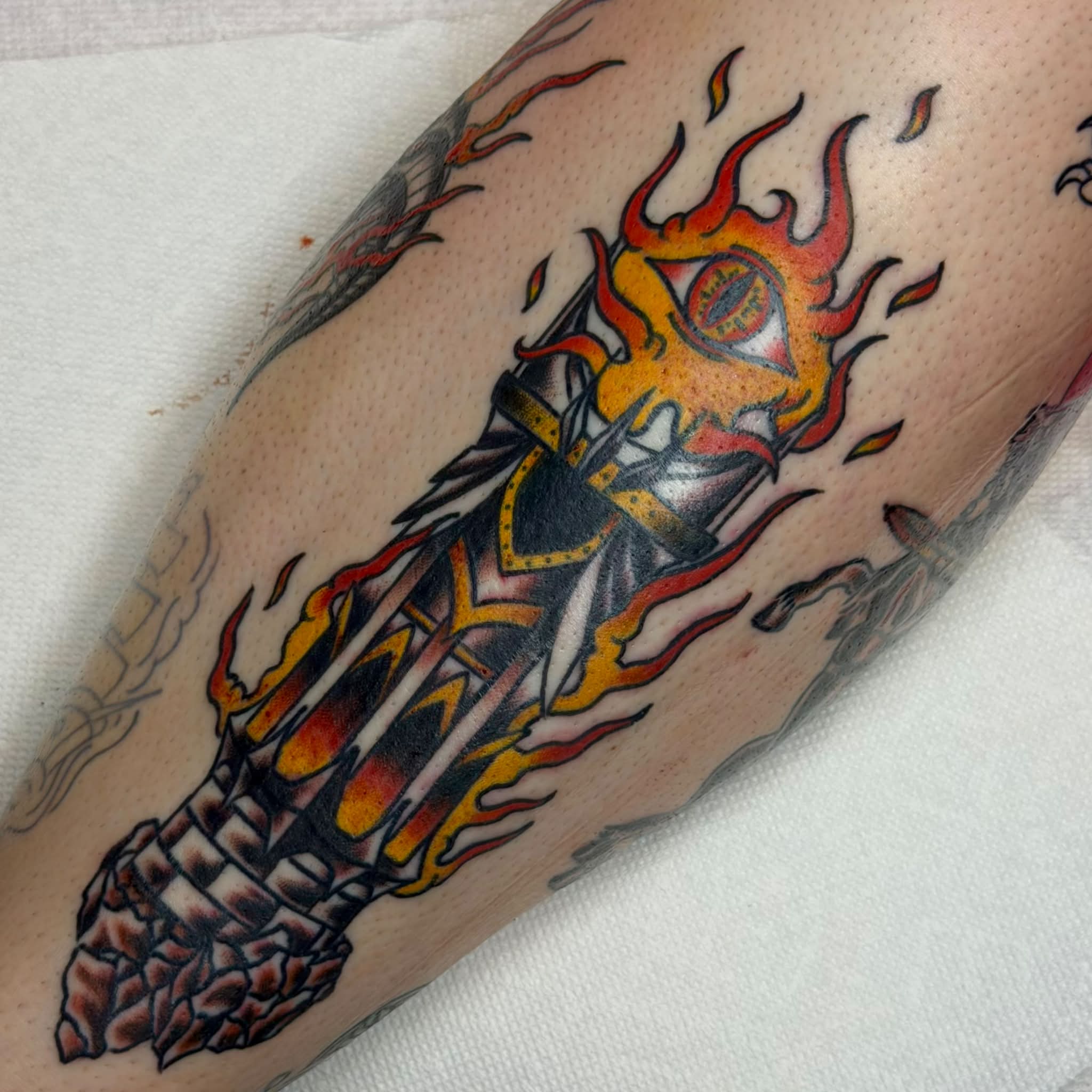 Flame and cross American traditional tattoo on the forearm by Kenneth Prince