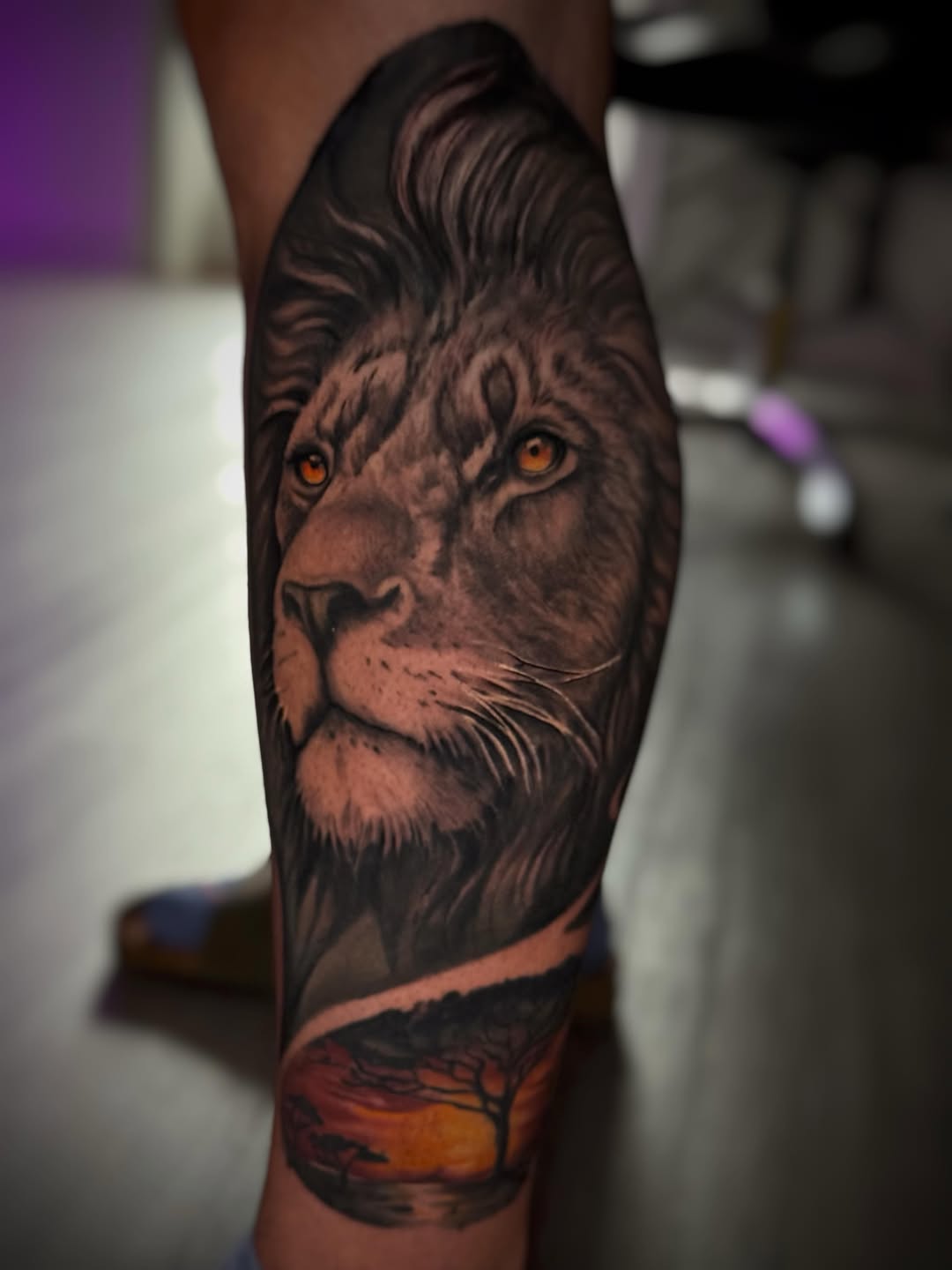 Lion portrait with savanna sunset realism tattoo on the forearm by Juan Russo