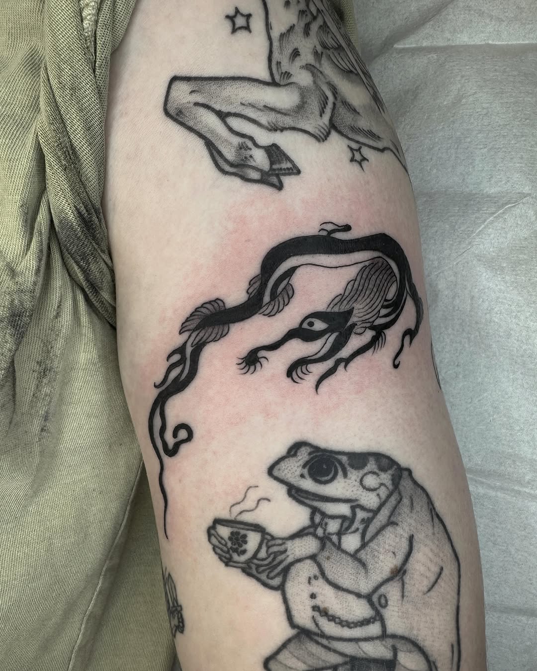 Mythical creature and frog drinking tea minimalist tattoo on the forearm by Amelia Rose, Los Angeles, California