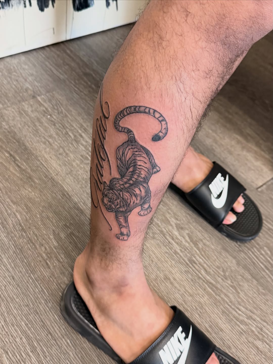 Tiger with script lettering realism tattoo on the calf by Shine Jefferson, Memphis, Tennessee