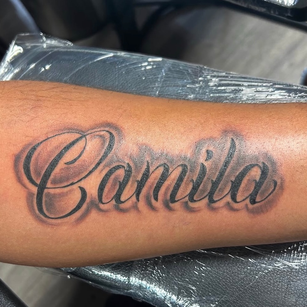 Camila name lettering lettering tattoo on the forearm by Vanessa - Dallas Artist