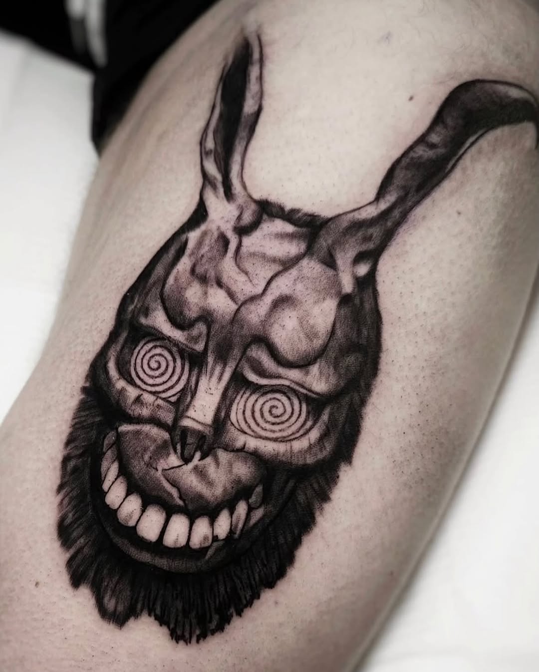 Frank the Rabbit mask dark art tattoo on the thigh by Brooke Kresco