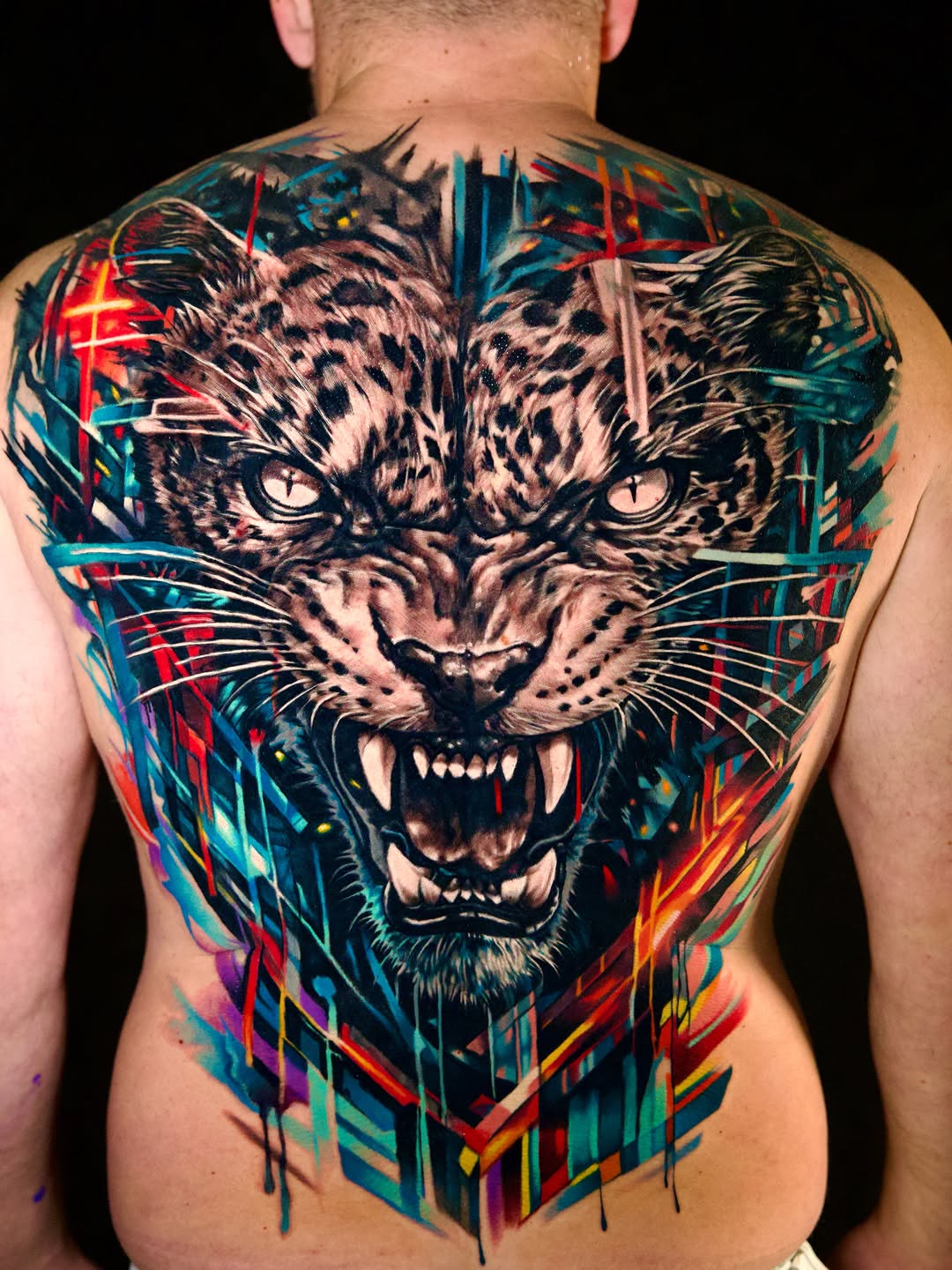 Leopard face with abstract background watercolor tattoo on the back by Israel De Jesus Legonier Aguliera
