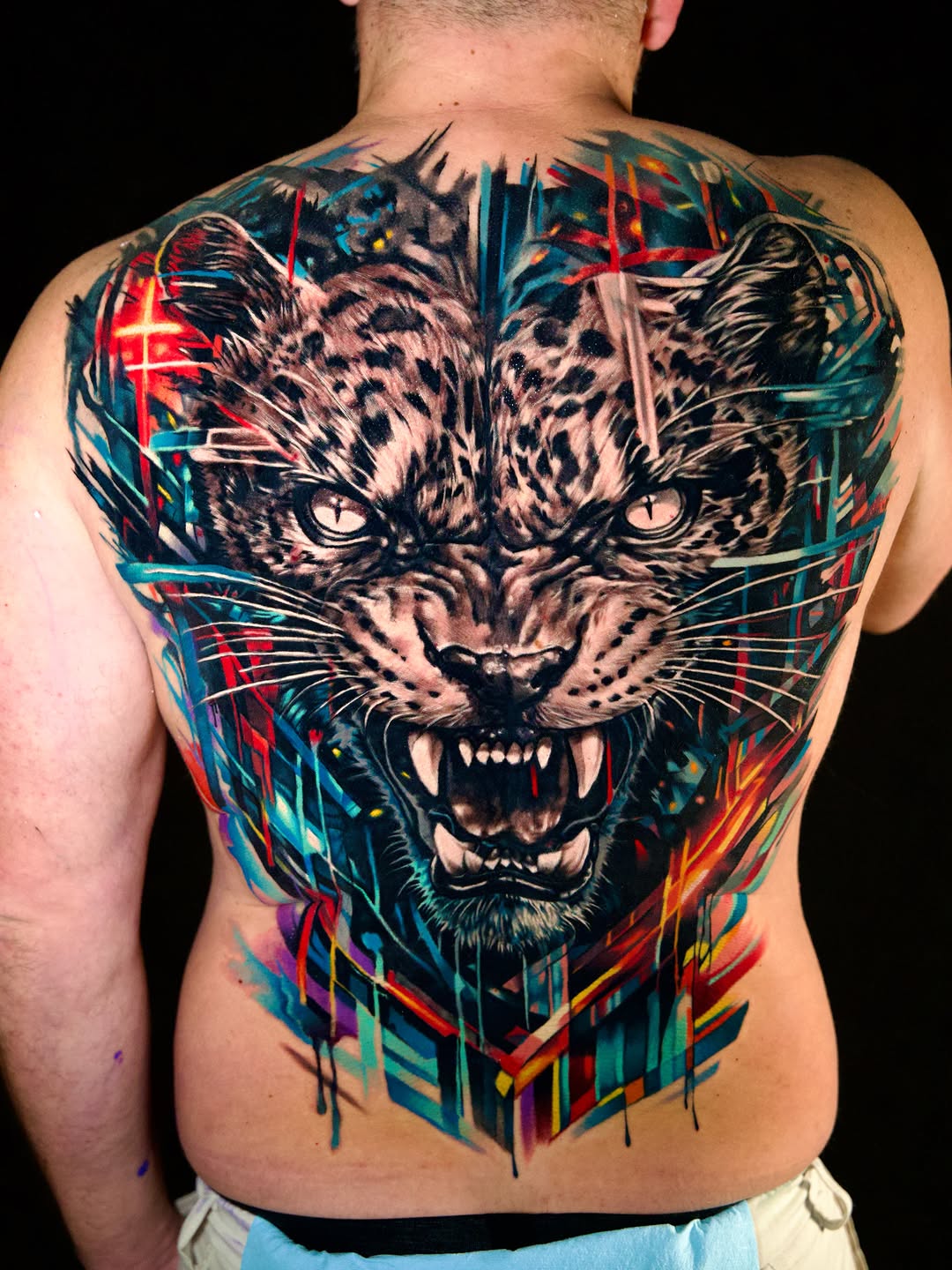 Leopard face with abstract background realism tattoo on the back by Israel De Jesus Legonier Aguliera