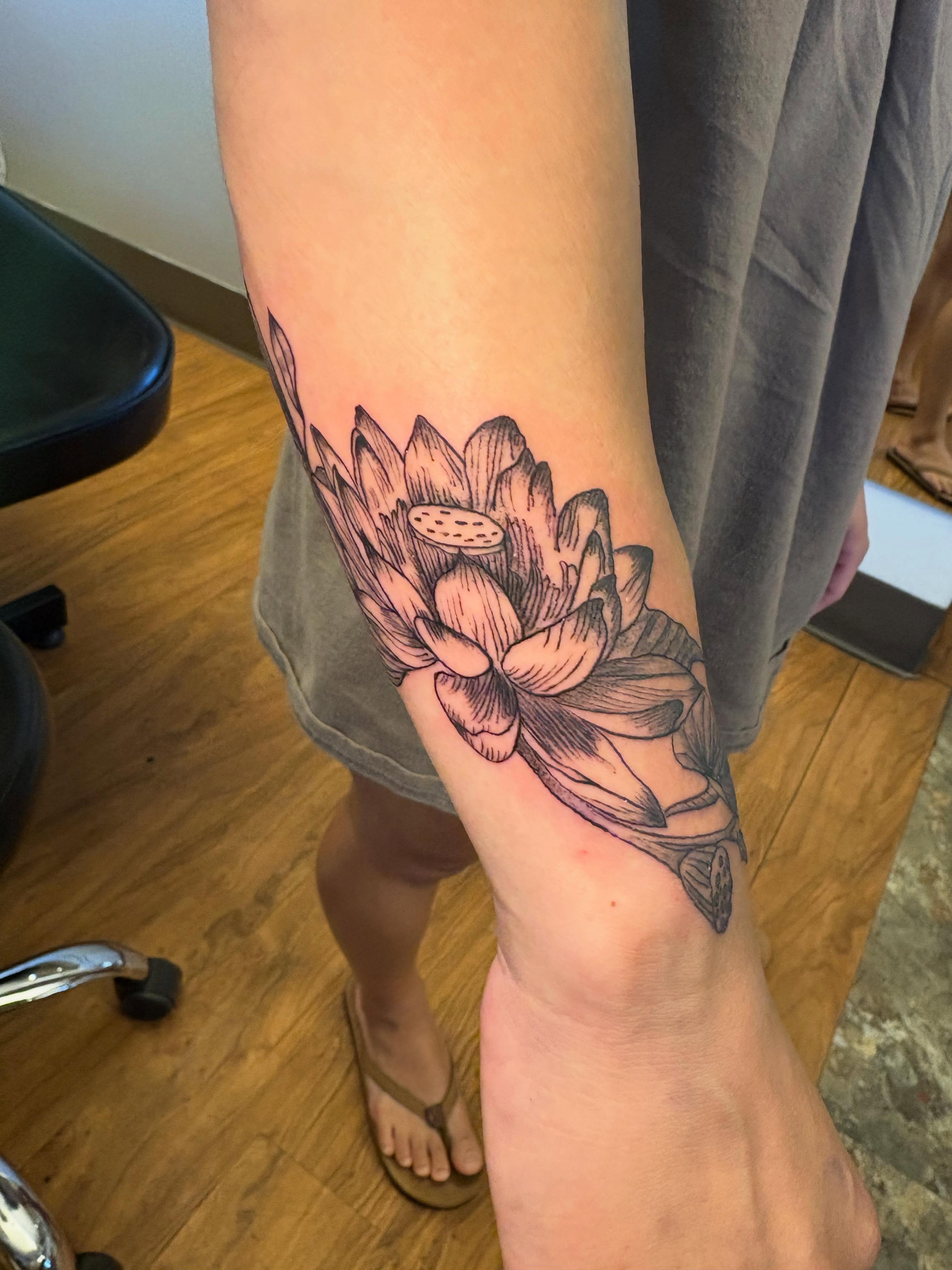 Lotus flower black and grey tattoo on the forearm by Luke