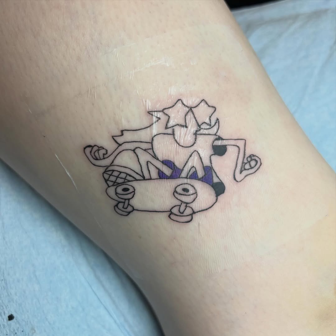 Cartoon character on skateboard fine line tattoo on the forearm by riley