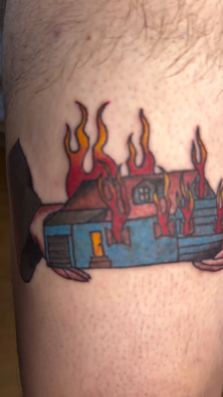 Burning house with flames American traditional tattoo on the upper arm by Giana Masso