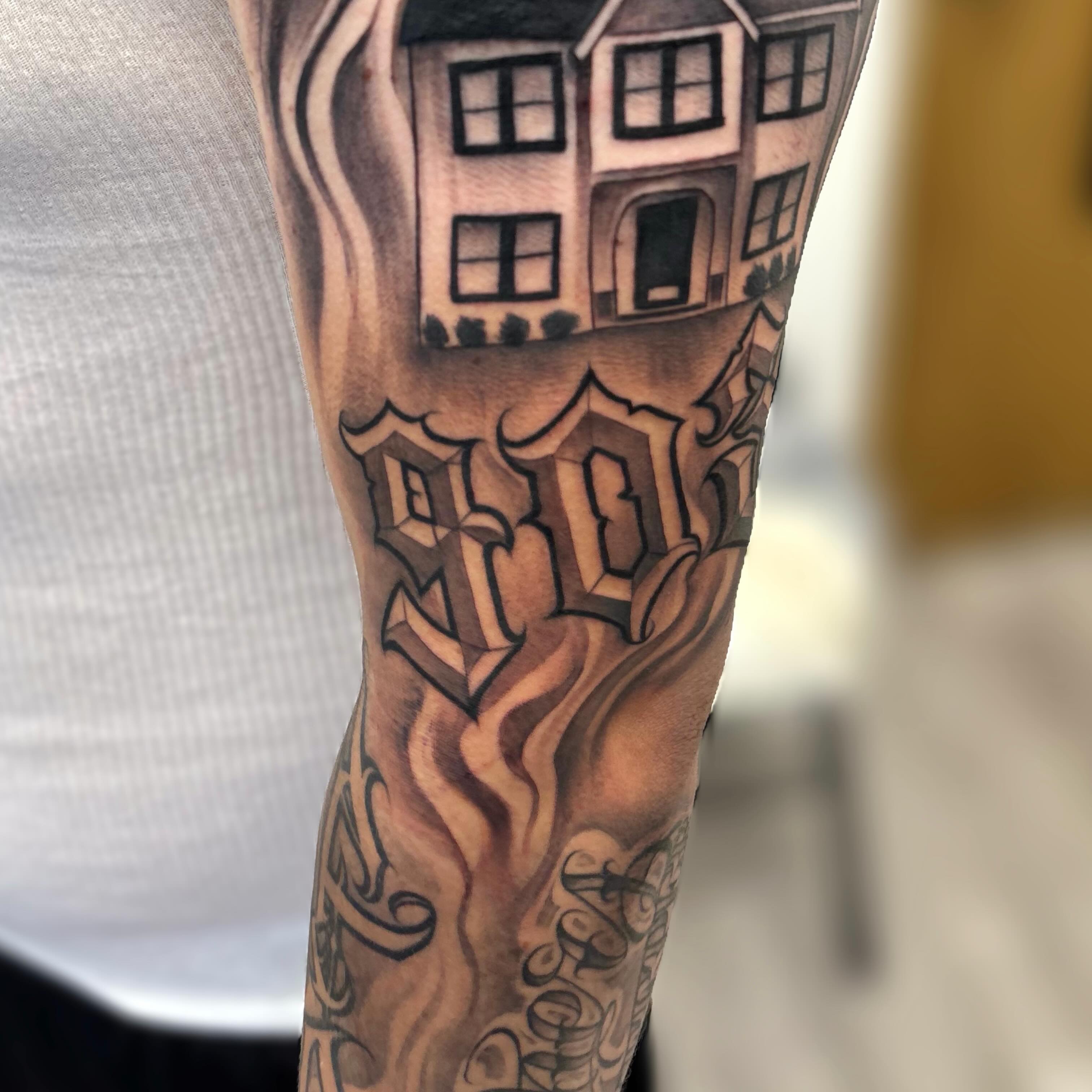 Building and lettering realism tattoo on the forearm by Dallas Tattoo Artist