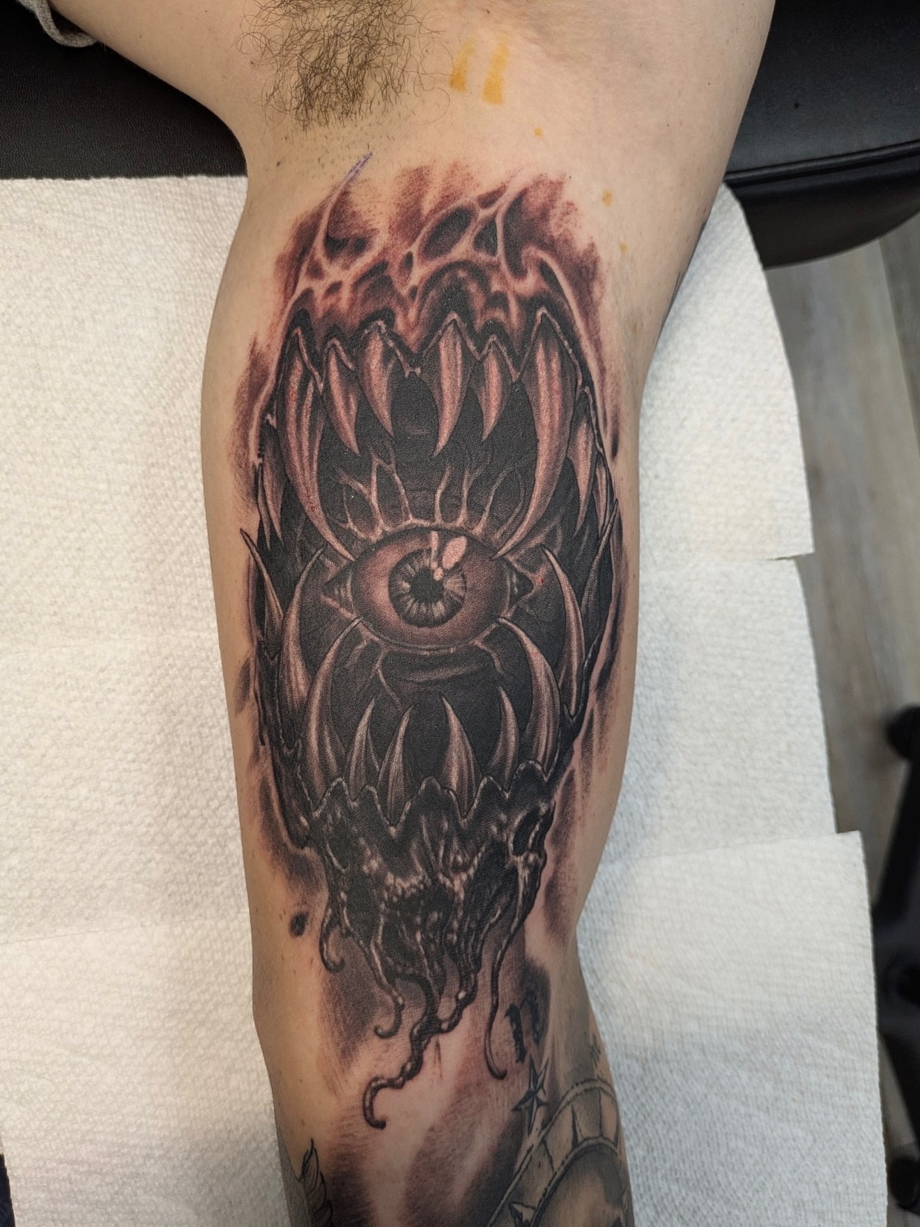 Eye with tentacles dark realism tattoo on the forearm by Buddy K.