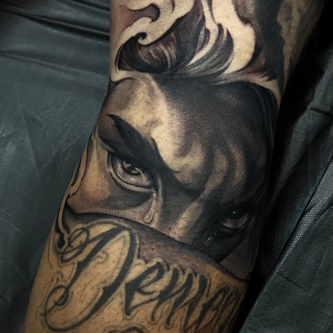 Face with tear and lettering realism tattoo on the forearm by Las Vegas tattoo Artist