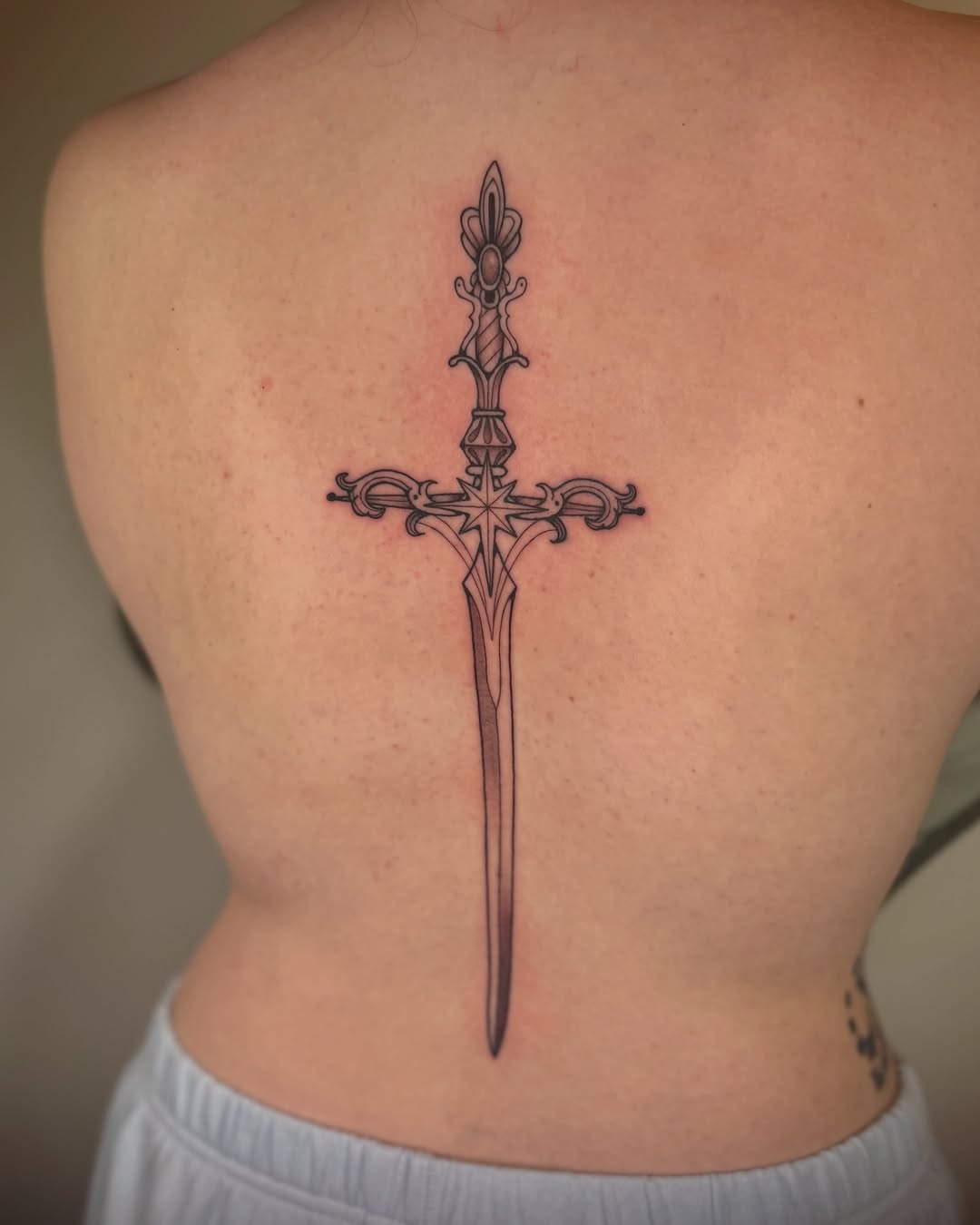 Ornate sword ornamental tattoo on the back by Kail