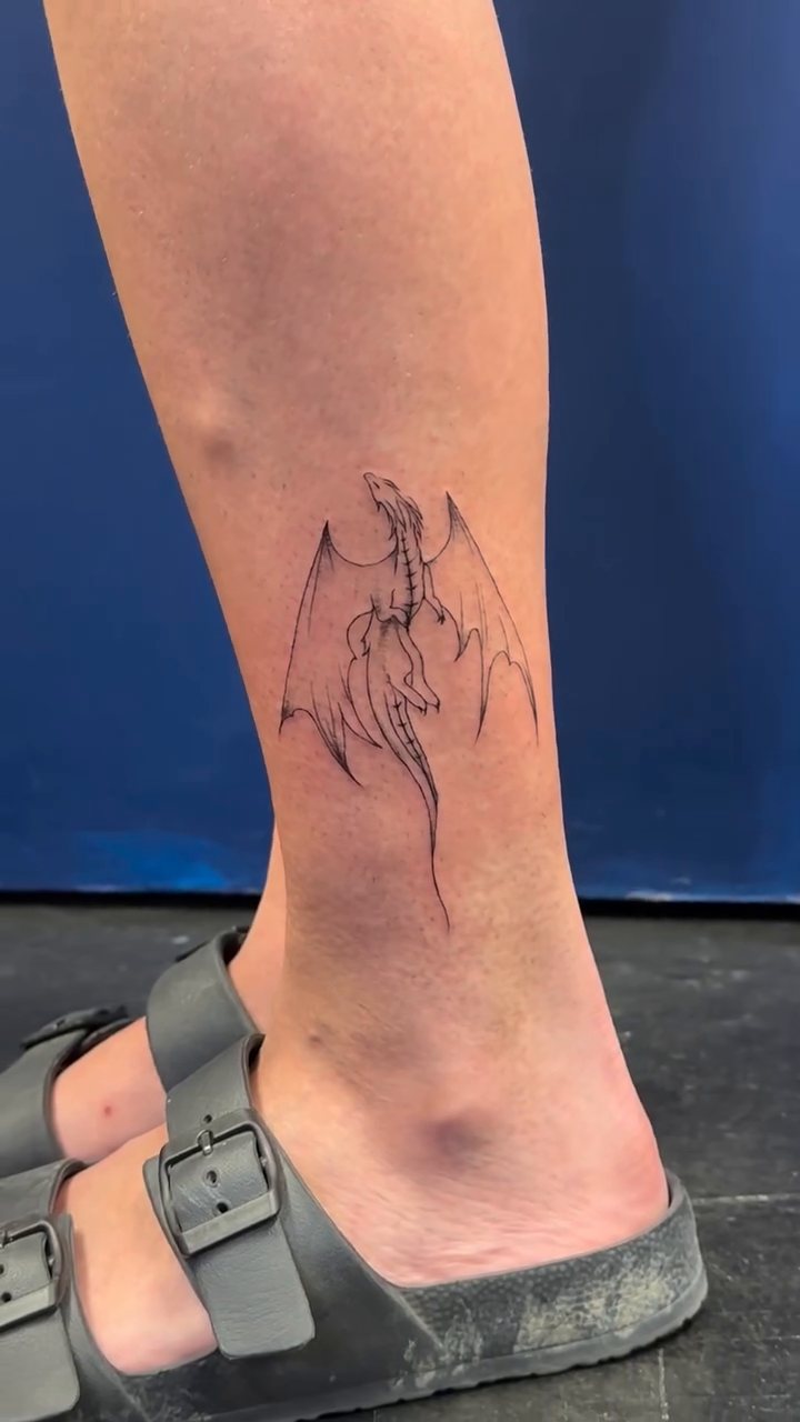 Dragon tattoo fine line tattoo on the calf by Tattoo Takayo