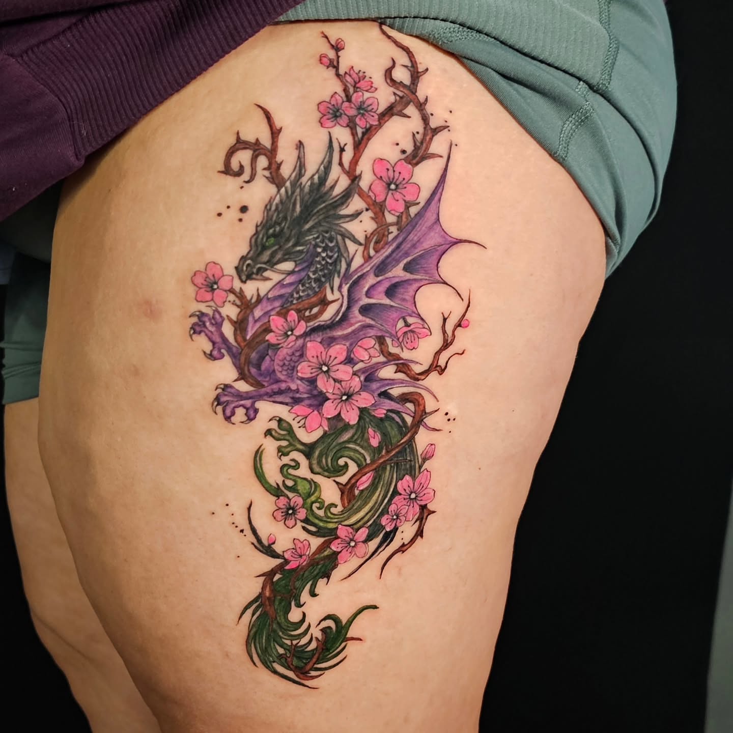 Dragon and cherry blossoms dotwork tattoo on the thigh by Lili Gu