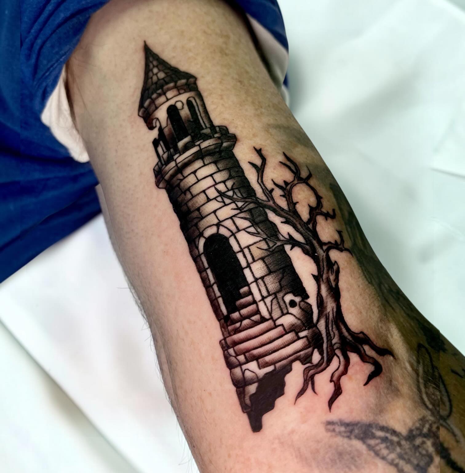 Castle tower black and grey tattoo on the forearm by Brooke Kresco