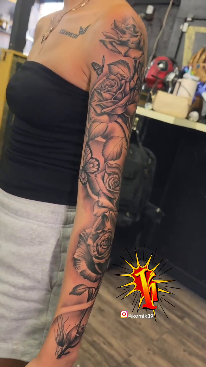 Full sleeve of roses and butterflies realism tattoo on the upper arm by komik tattoos