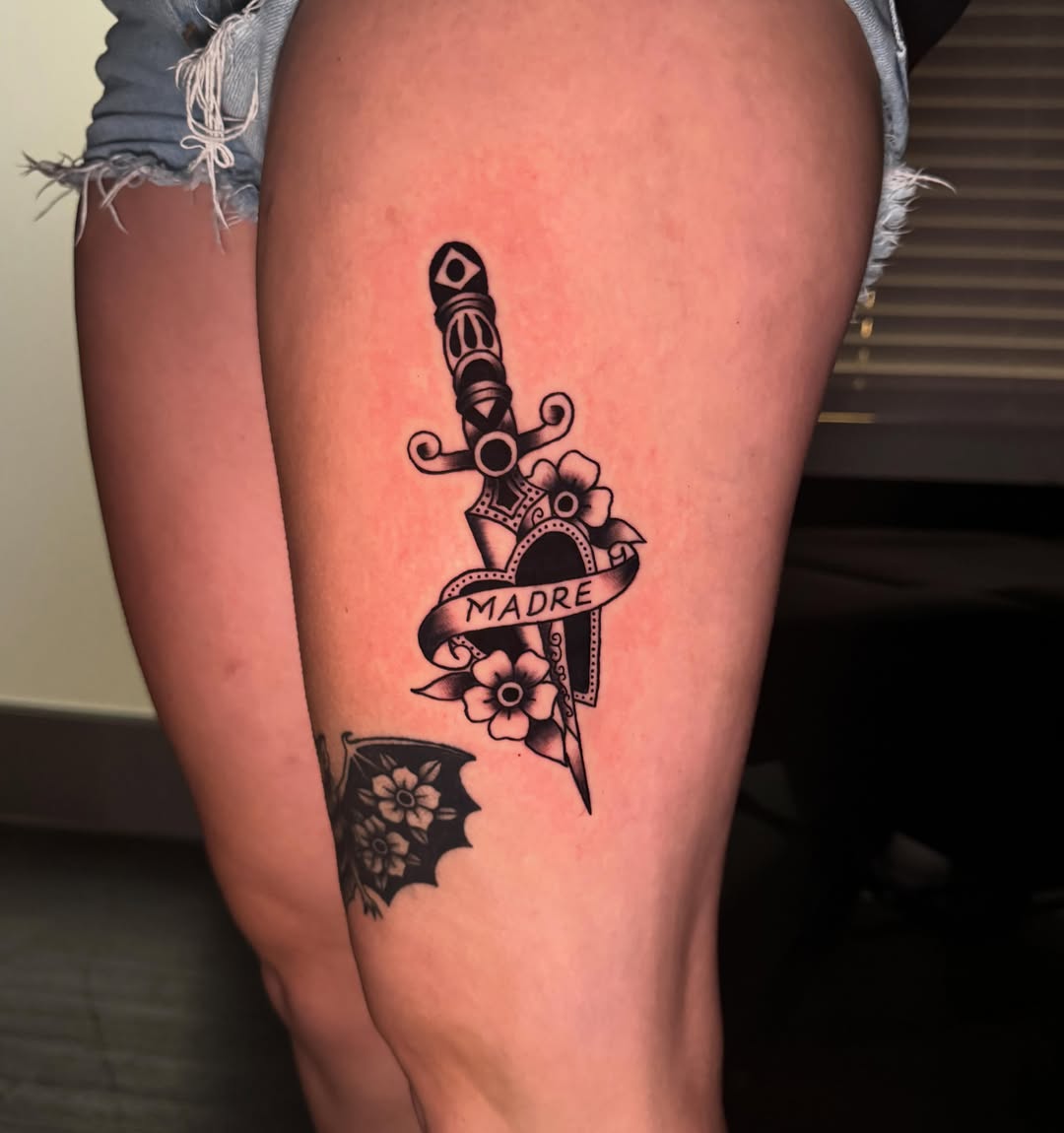 Sword and flowers American traditional tattoo on the thigh by Delaney Cooper