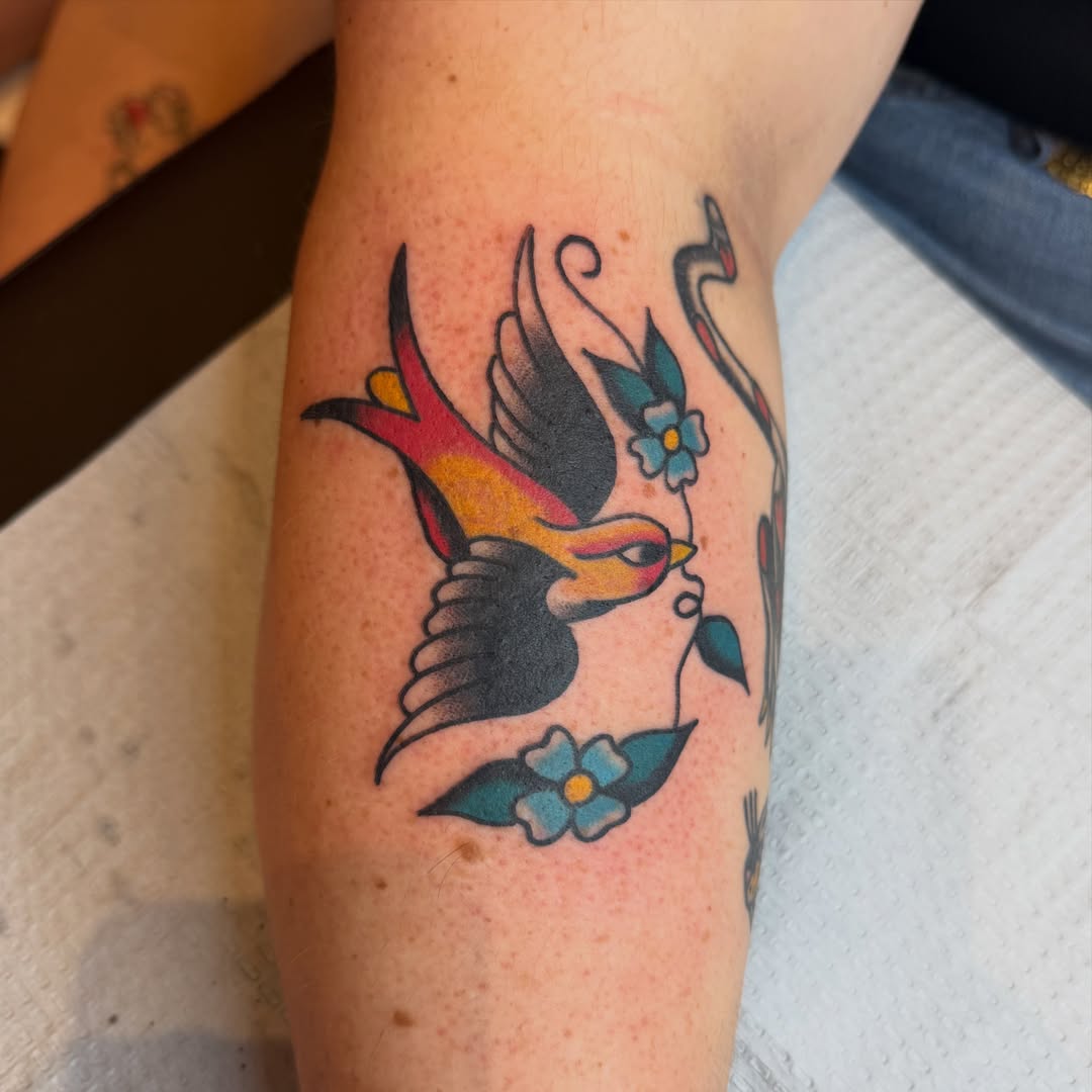 Bird and flowers American traditional tattoo on the forearm by Carl Testi