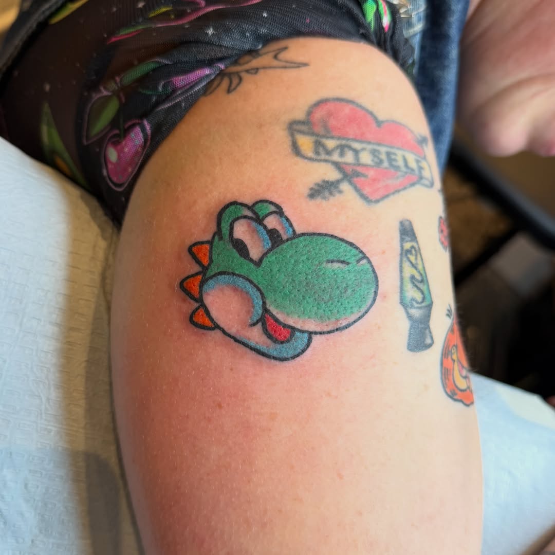 Yoshi new school tattoo on the thigh by Carl Testi
