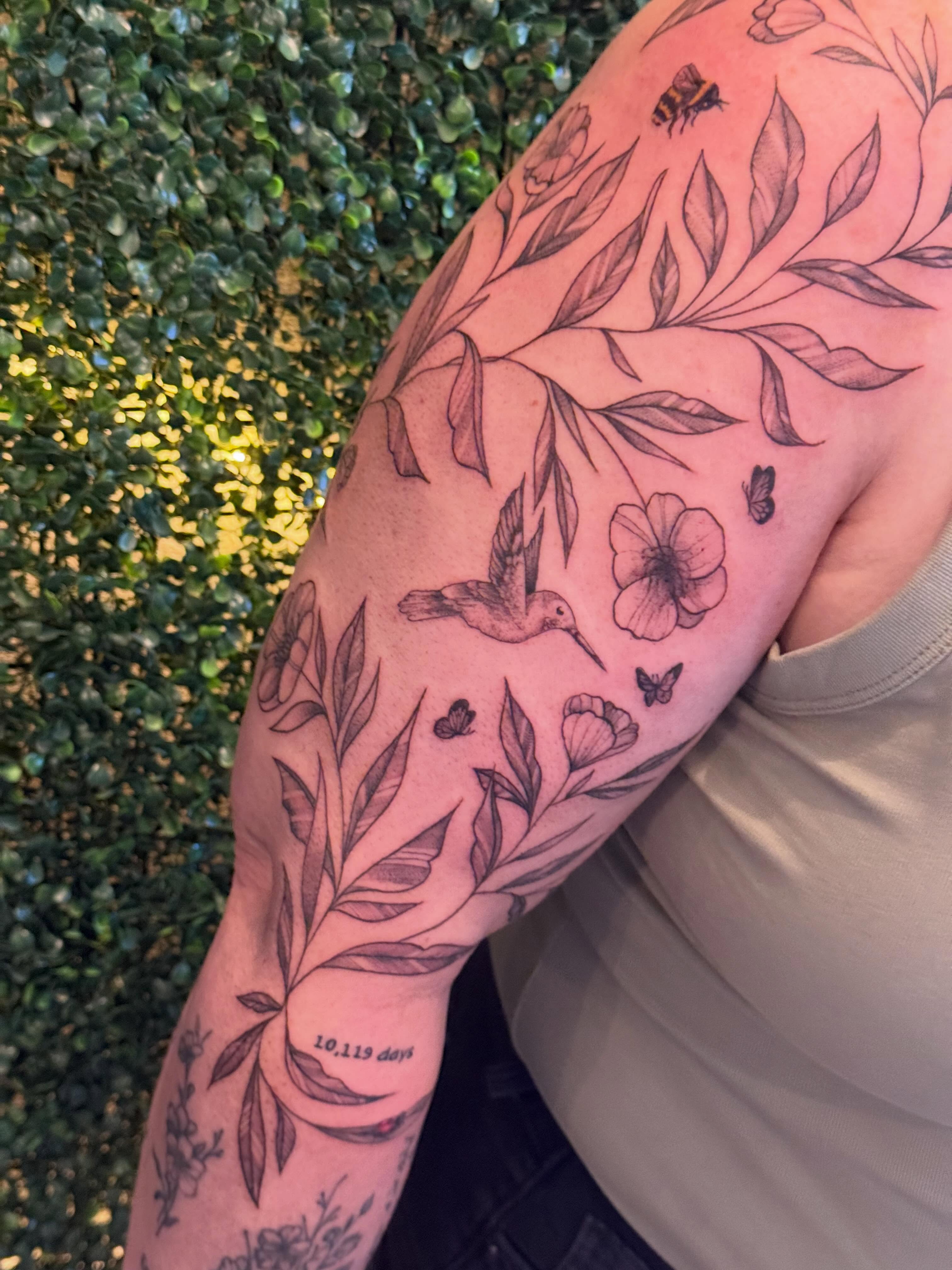 Botanical black and grey tattoo on the upper arm by Lauren Horness