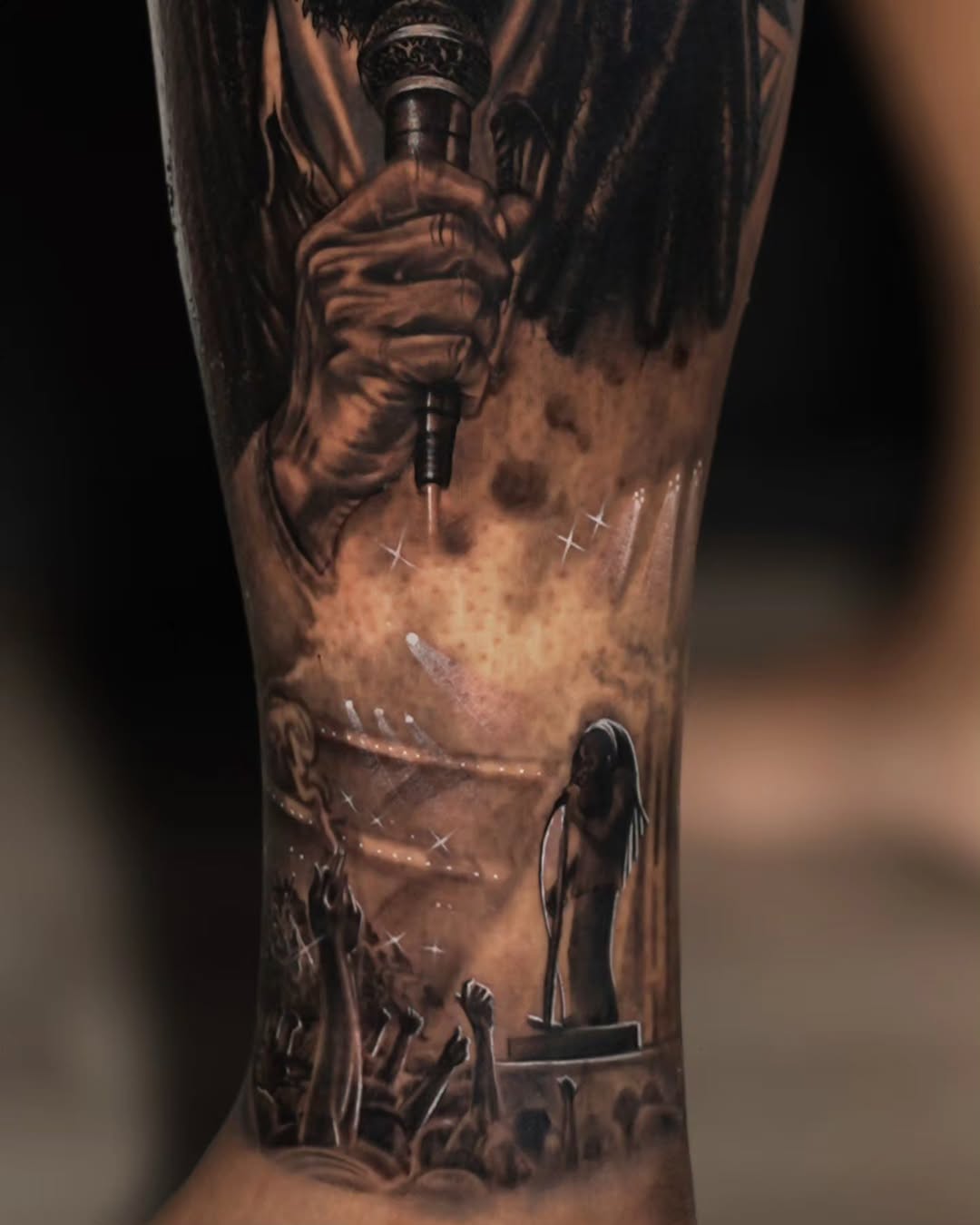 Singer performing on stage with crowd surrealism tattoo on the forearm by Baxtertattoo
