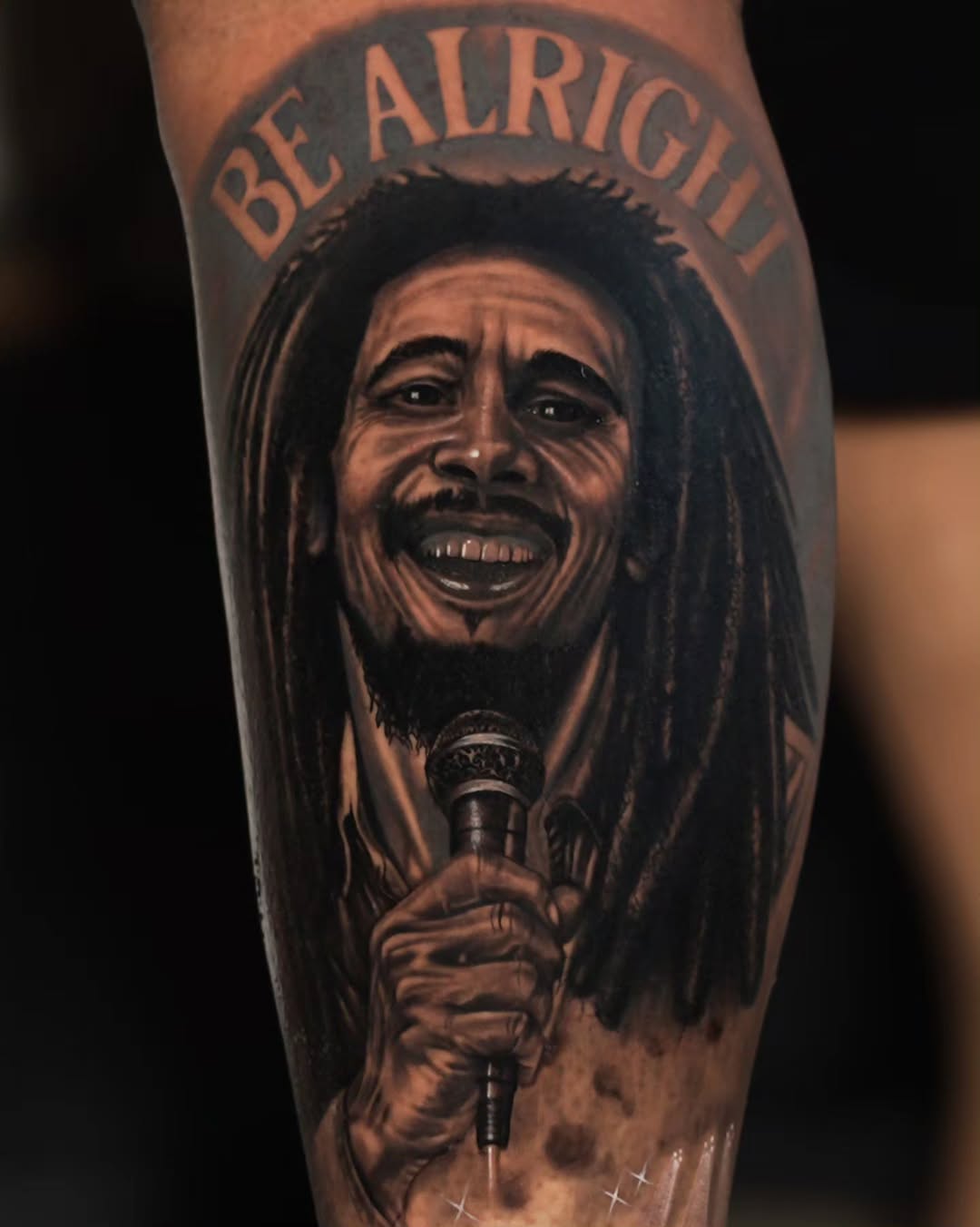 Bob Marley portrait with microphone realism tattoo on the forearm by Baxtertattoo