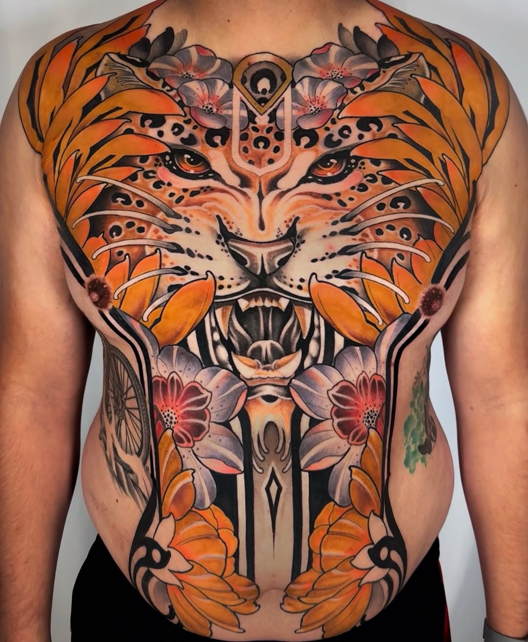 Tiger face with flowers realism tattoo on the chest by Aitor Arie, Roseville, California