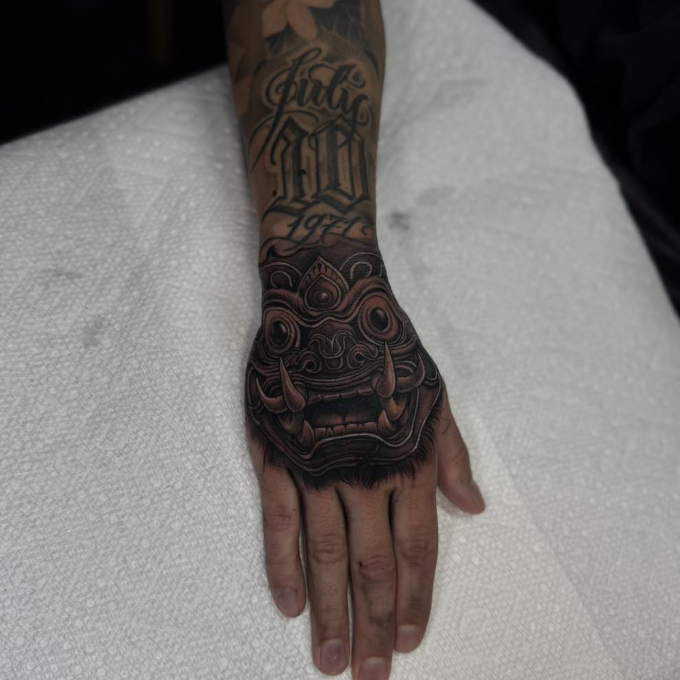 Mask realism tattoo on the hand by Isaac
