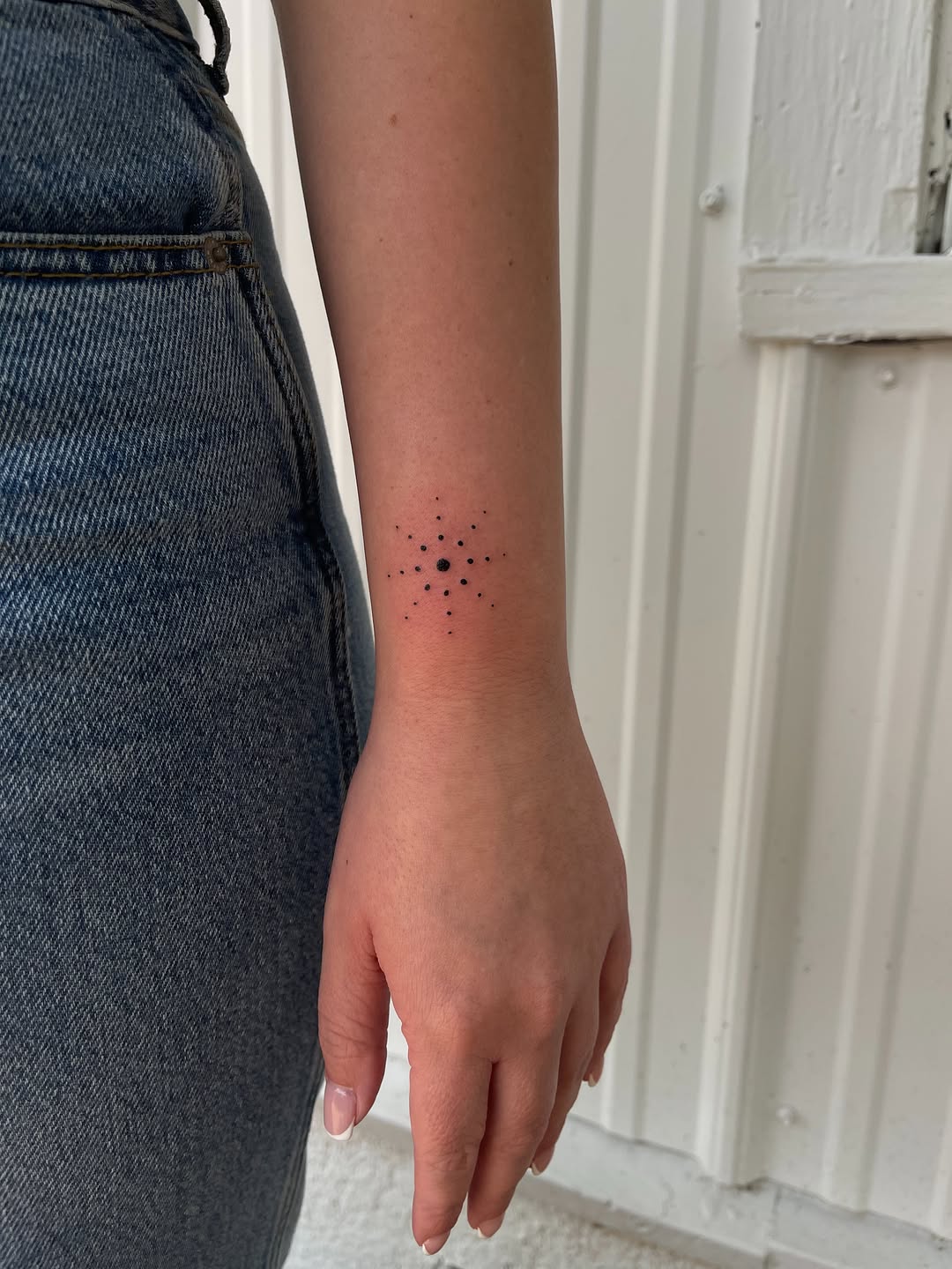 Geometric starburst ornamental tattoo on the forearm by Amy