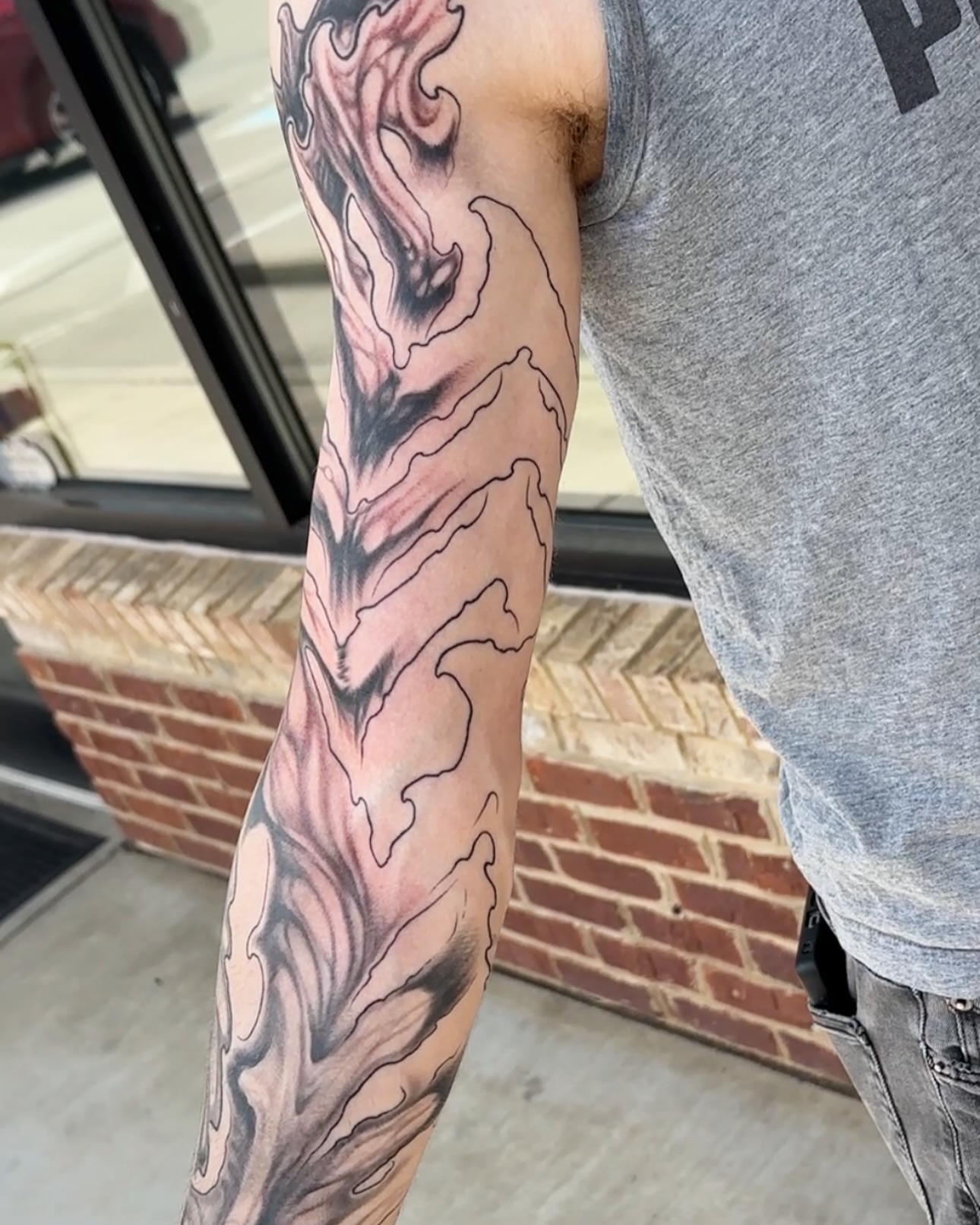 Flame black and grey tattoo on the forearm by Skylar Mangrum
