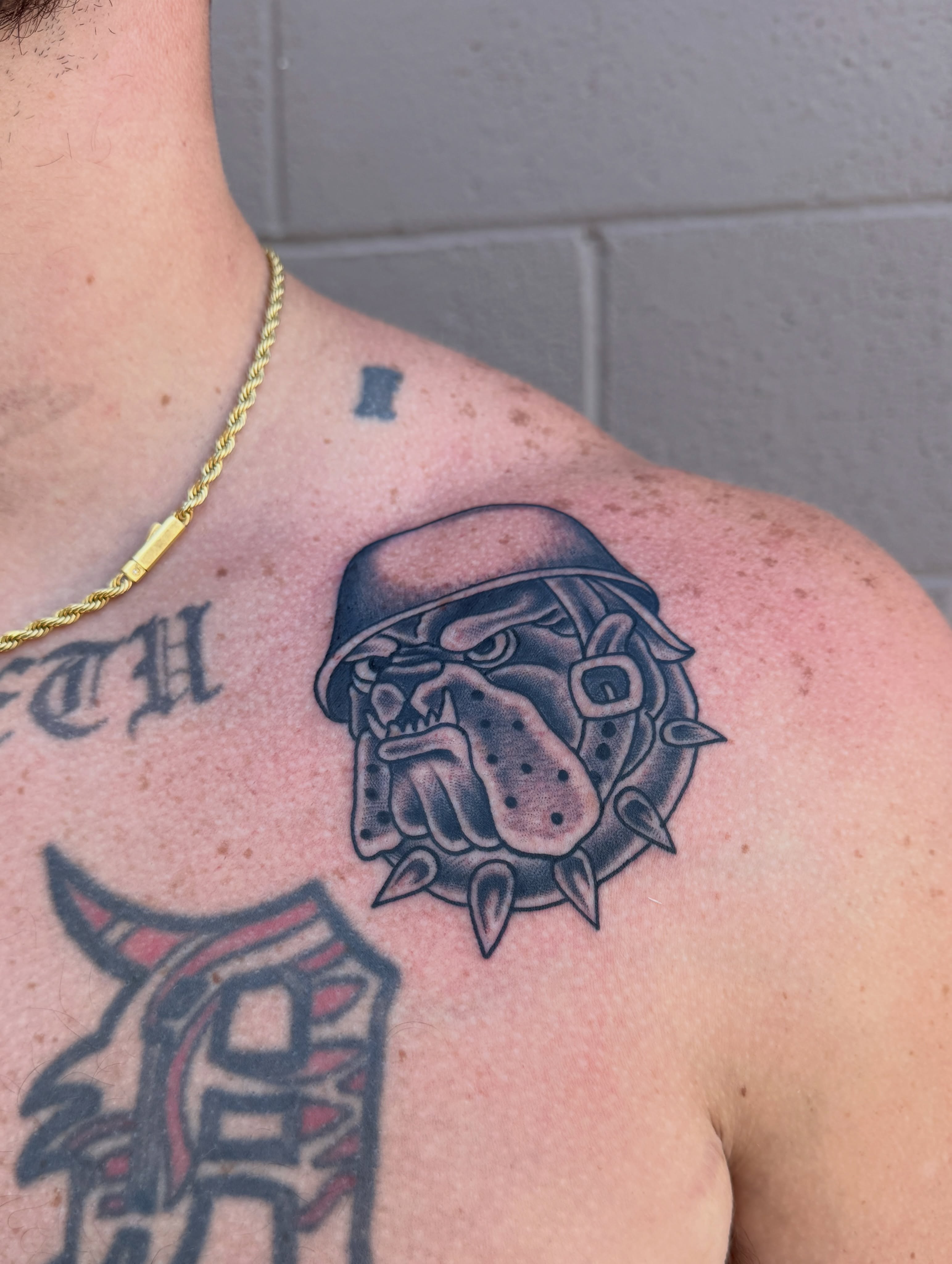 Bulldog helmet black and grey tattoo on the shoulder by Butch Mickle