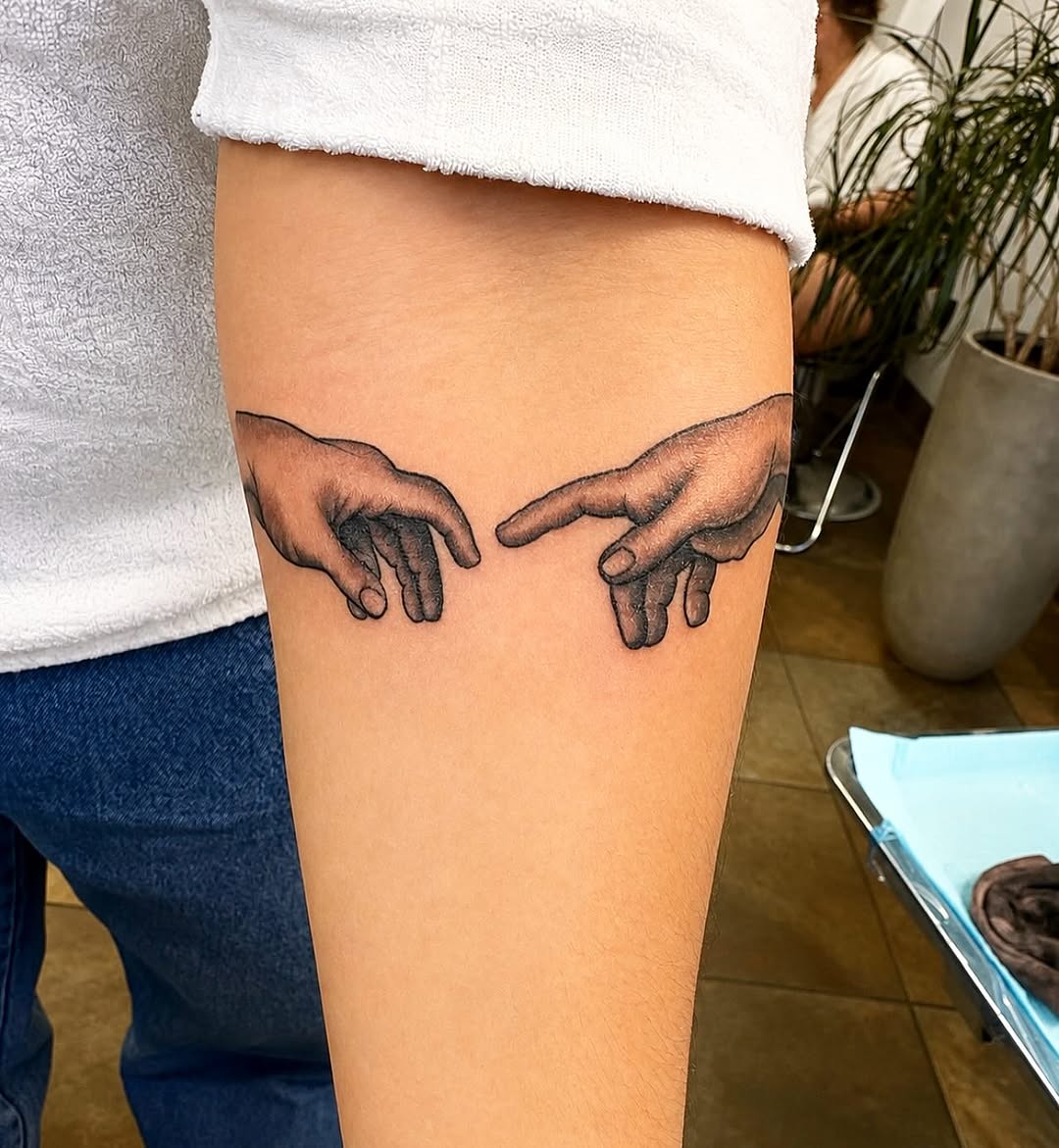 The Creation of Adam hands surrealism tattoo on the thigh by Stoney
