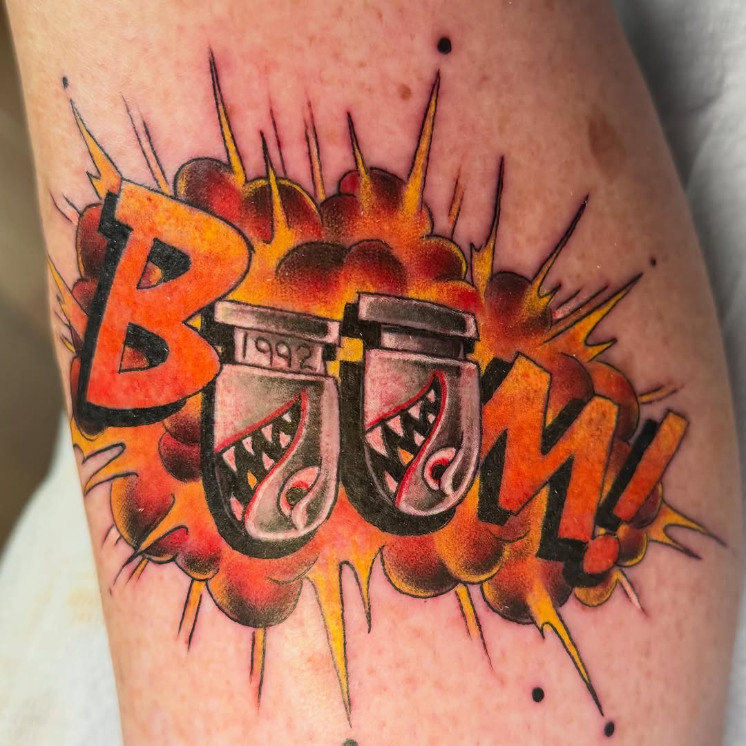 BOOM text with two grenades American traditional tattoo on the forearm by Bryan Hunt