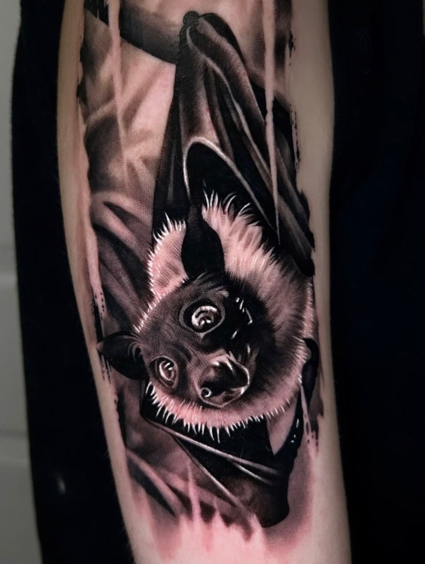 Bat hanging upside down dark art tattoo on the forearm by Dallas Corsmeier