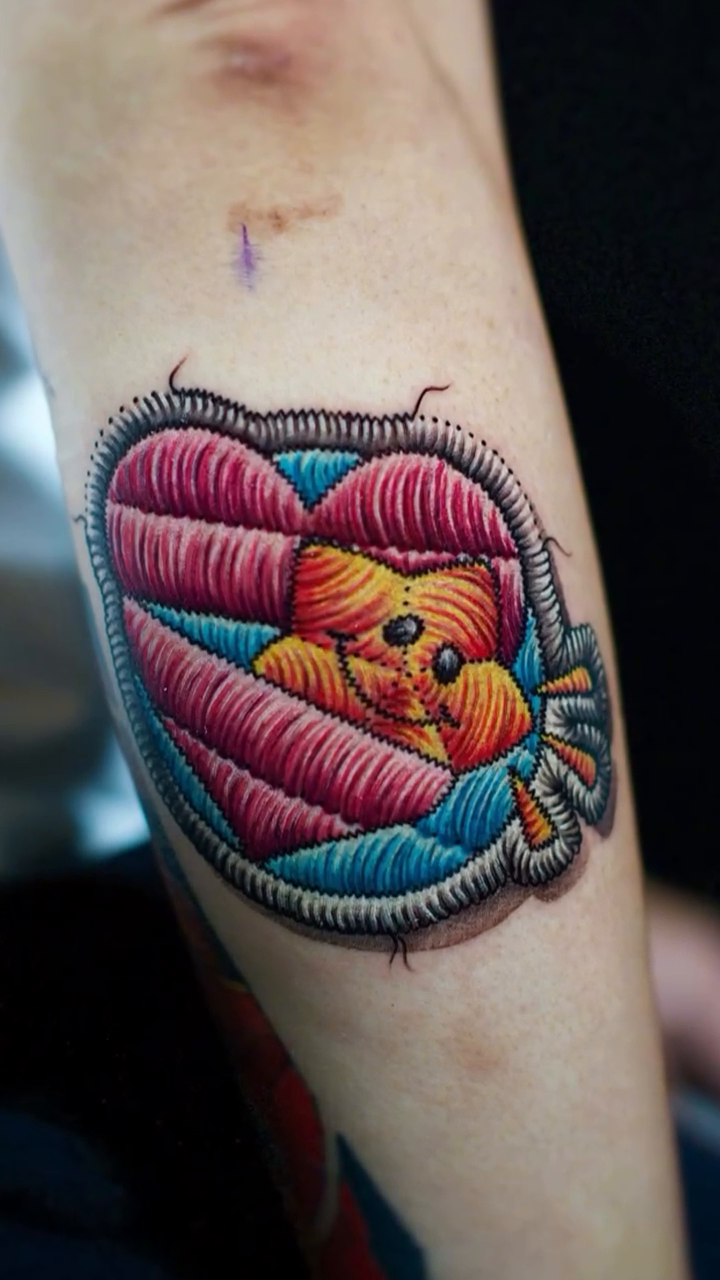 Teddy bear and heart tattoo on the forearm by Yana Aizen