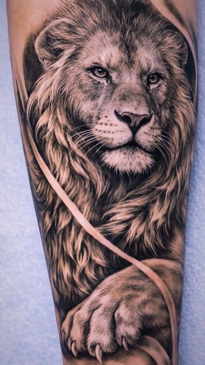 Lion portrait with flowing elements Chicano tattoo on the forearm by Mak$ Brand