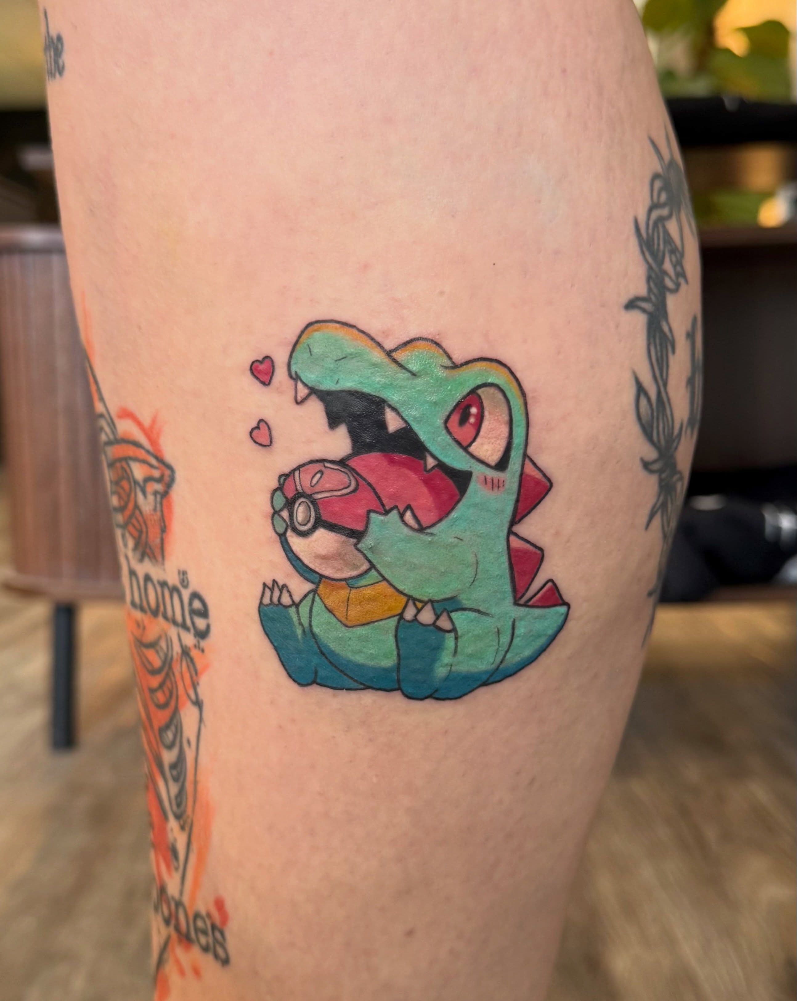 Dragon with Poké Ball new school tattoo on the forearm by Kate Marie