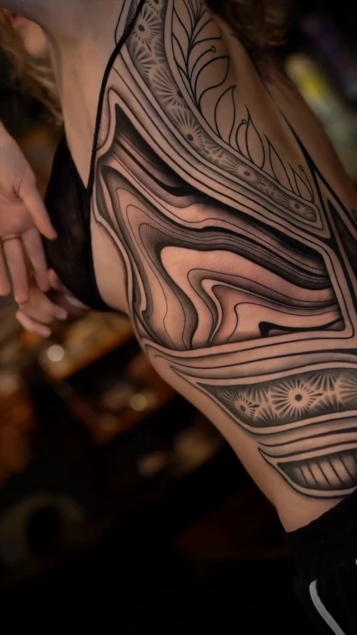 Abstract flowing lines on torso surrealism tattoo on the torso by Haley Corinne