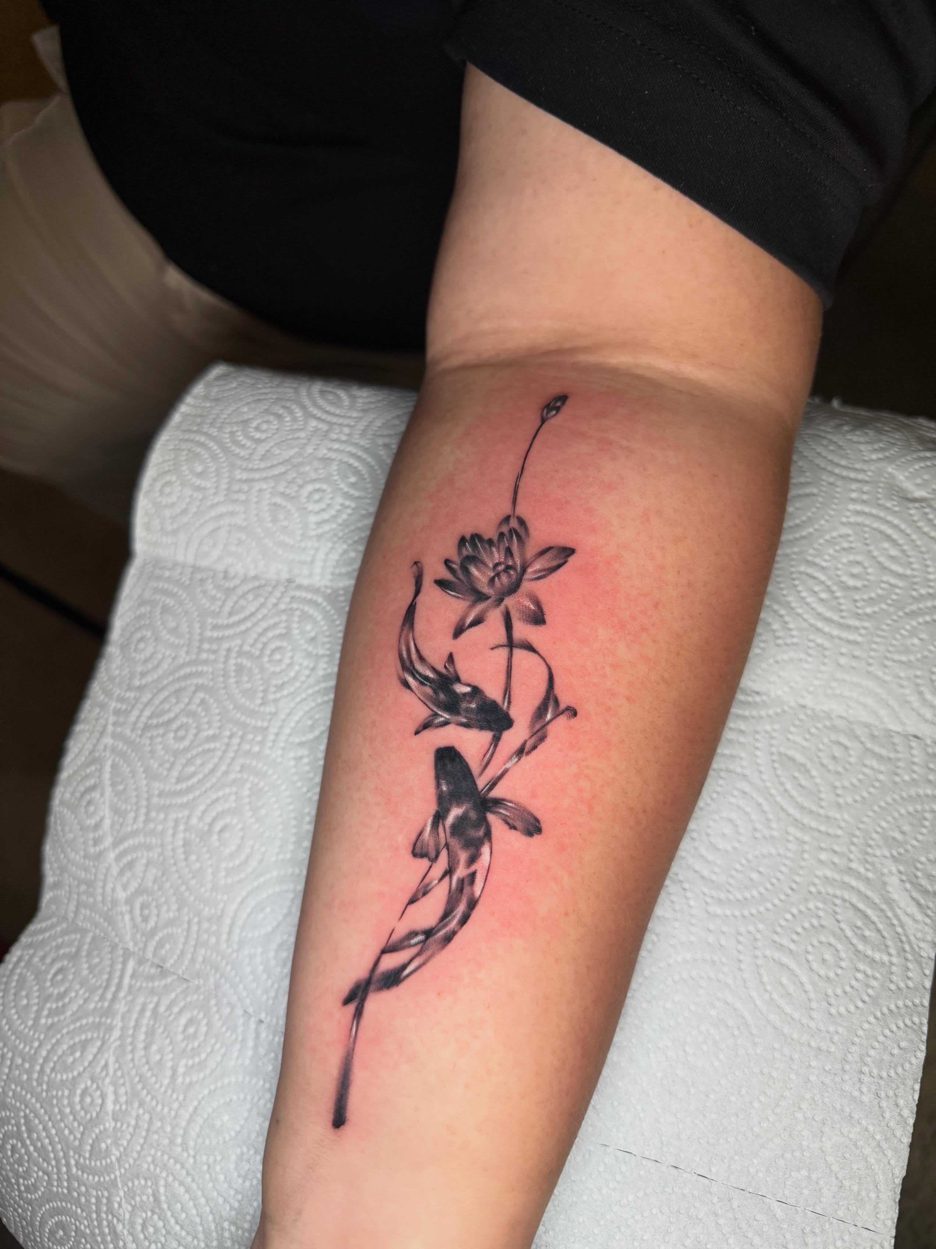 Lotus and koi fish black and grey tattoo on the forearm by Steve - Tattoo Artist