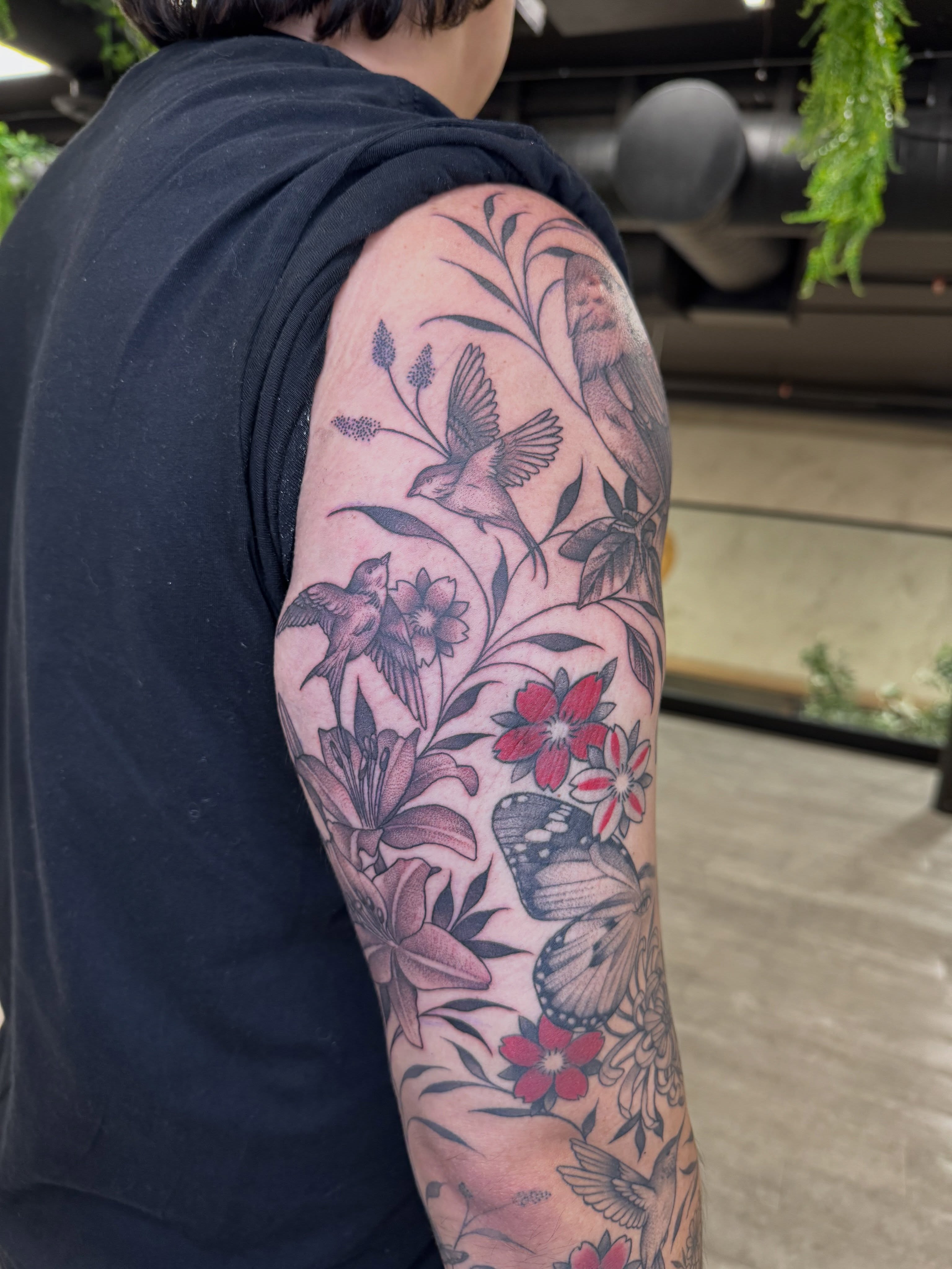 Floral and bird realism tattoo on the upper arm by Tara Crespi - Female Tattoo Artist 💜