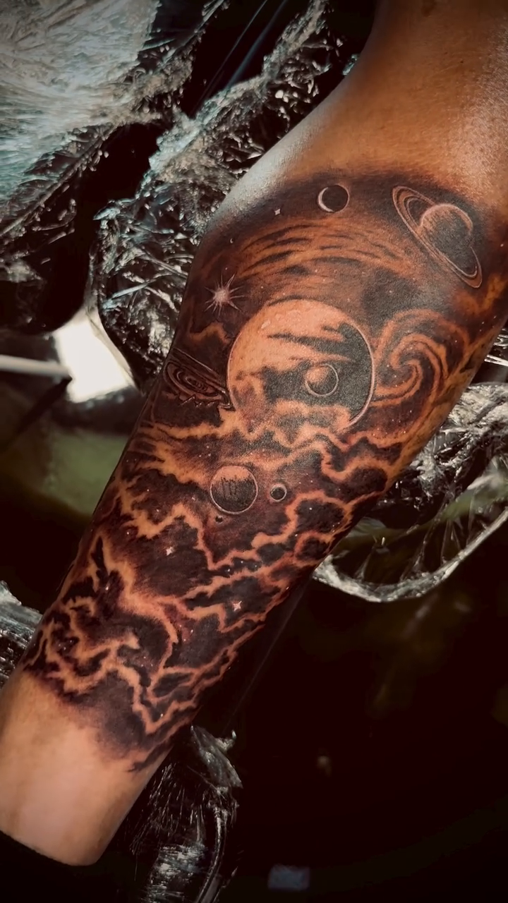 Cosmic scene with planets and clouds realism tattoo on the forearm by Erik Pagtakhan