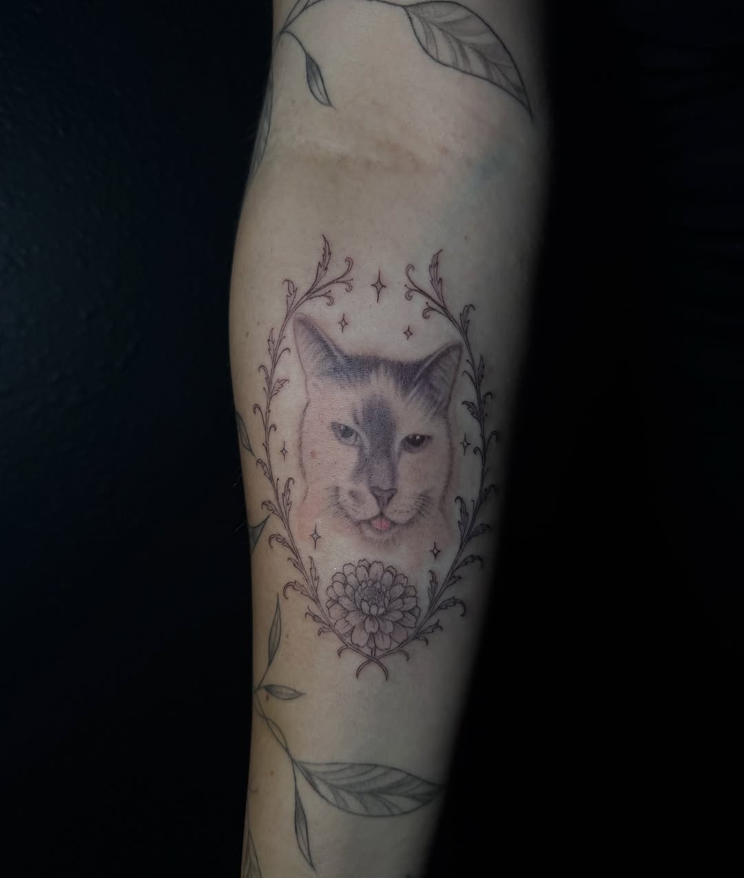 Cat portrait with floral frame realism tattoo on the forearm by Ink Darling, Carlisle, Iowa