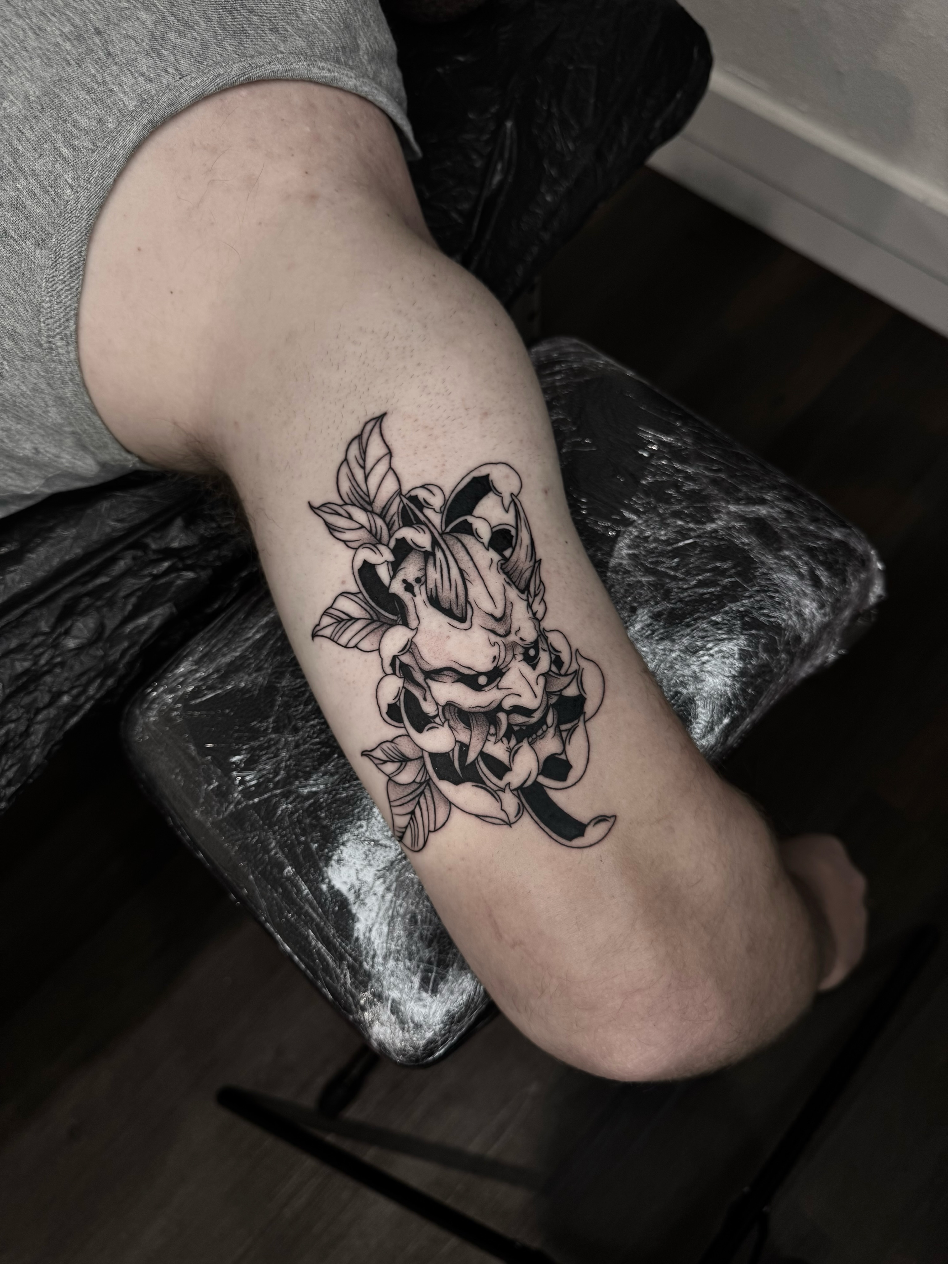 Demon mask black and grey tattoo on the forearm by Blackwork Vamos