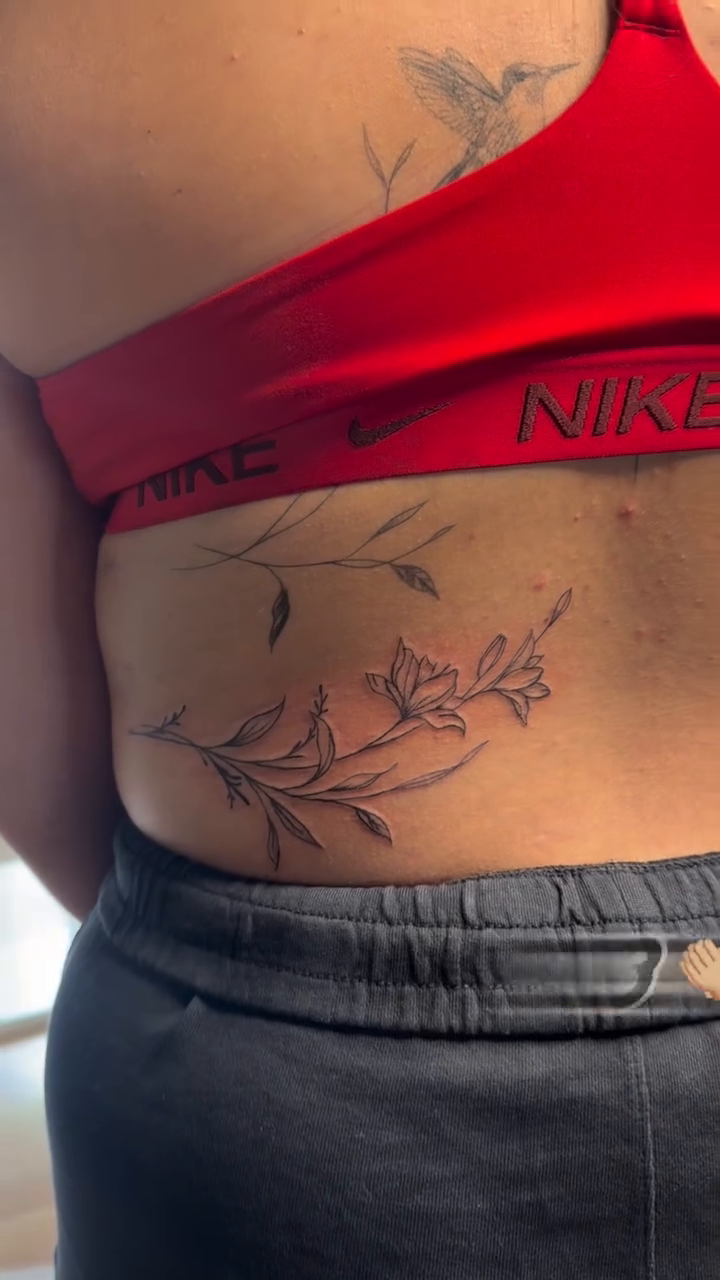 Floral sprig tattoo on lower back blackwork tattoo on the torso by TolzinInk, Brookings, South Dakota