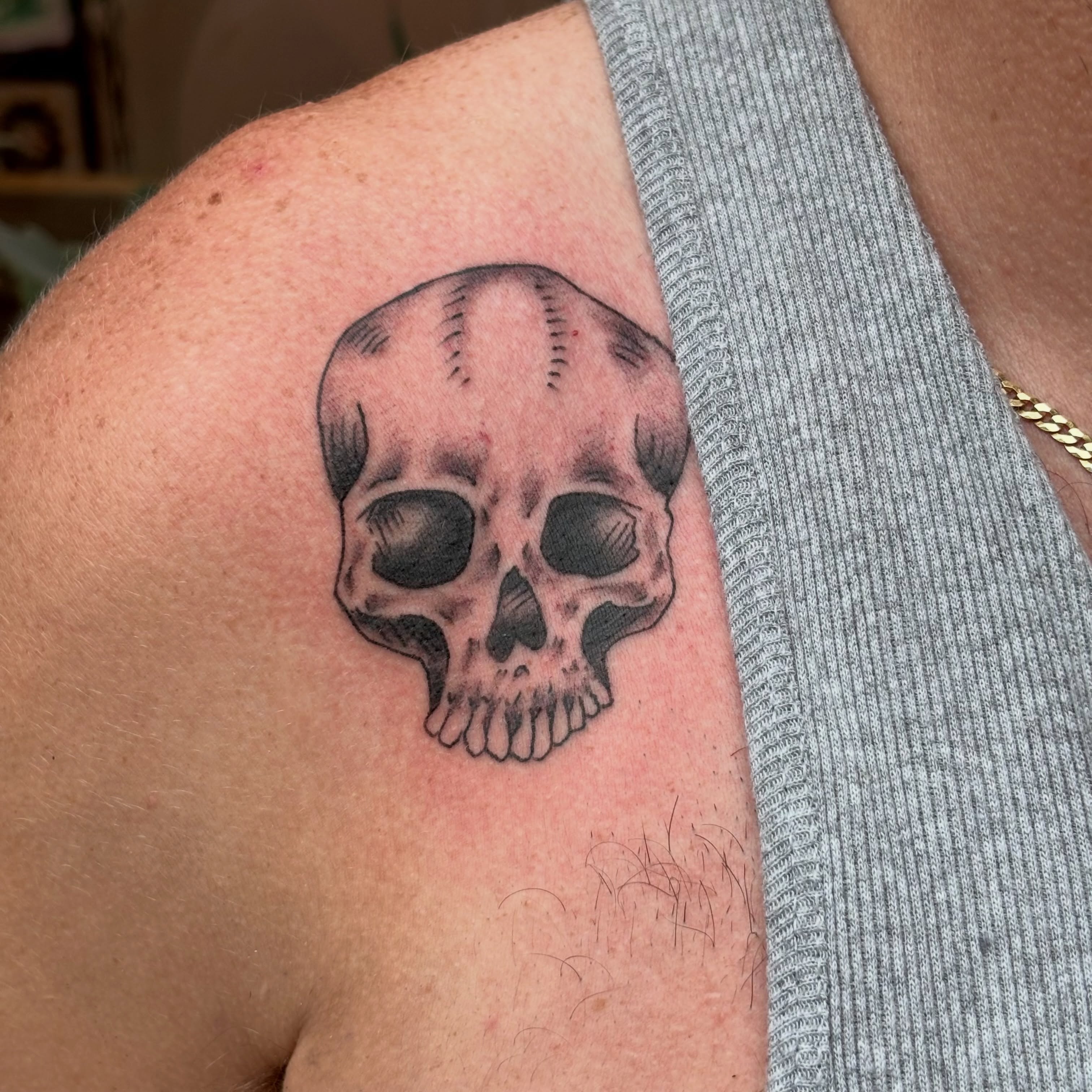 Skull black and grey tattoo on the shoulder by Malachi