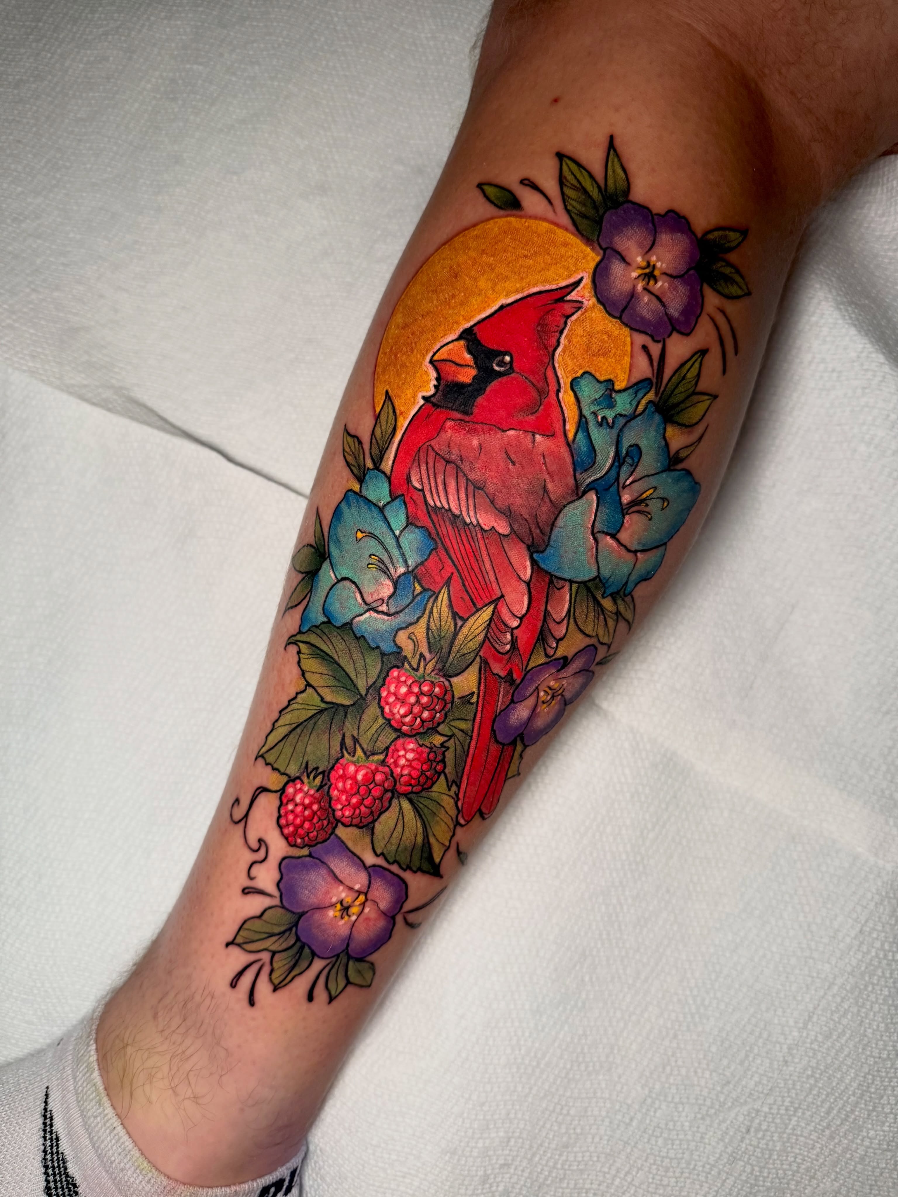 Cardinal and flowers American traditional tattoo on the forearm by Paul Endres Jr